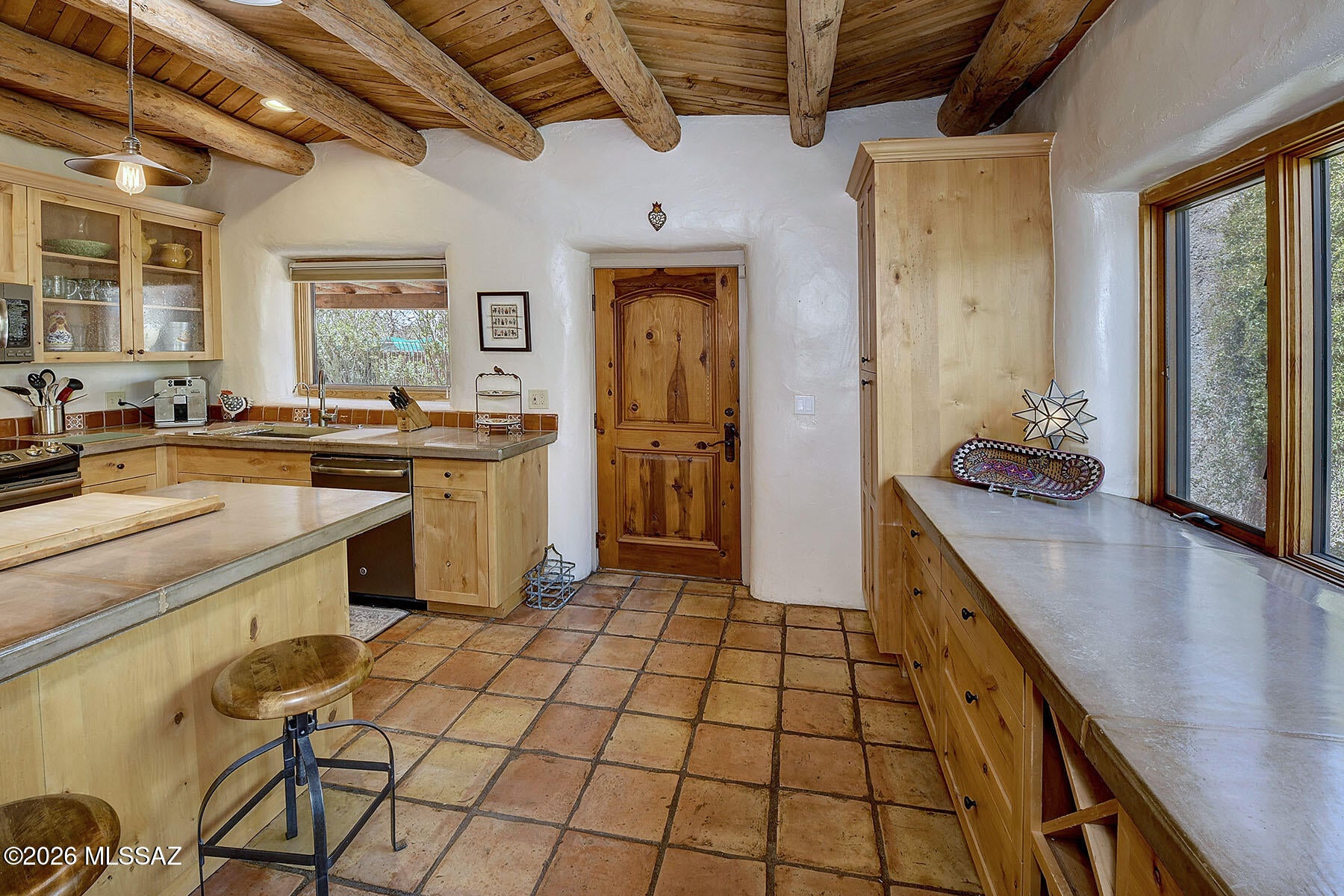 Take a step back in time...tucked w/i treasured Ft. Lowell Historic District within an enchanting enclave of only 12 custom homes. Crafted adobe style, it's quintessential Tucson living.  Handcrafted stabilized thick mud adobe-this wall system offers thermal properties ideal for the desert climate. Authentic architectural character: soaring wood viga beam/saguaro rib ceilings, adobe textured walls, authentic Mexican clay tile & masonry walls. Wood-burning fireplace. Solid wood window & door headers. Multiple wood French doors leading to Arizona Room & brick paved courtyards. This adobe home is 1-of-a-kind & stunning. Walk to the 130-mile Tucson Loop Trail, Plaza Palomino, Ft. Lowell Park or Historic San Pedro Chapel. Private & timeless authenticity, quality & craftsmanship.