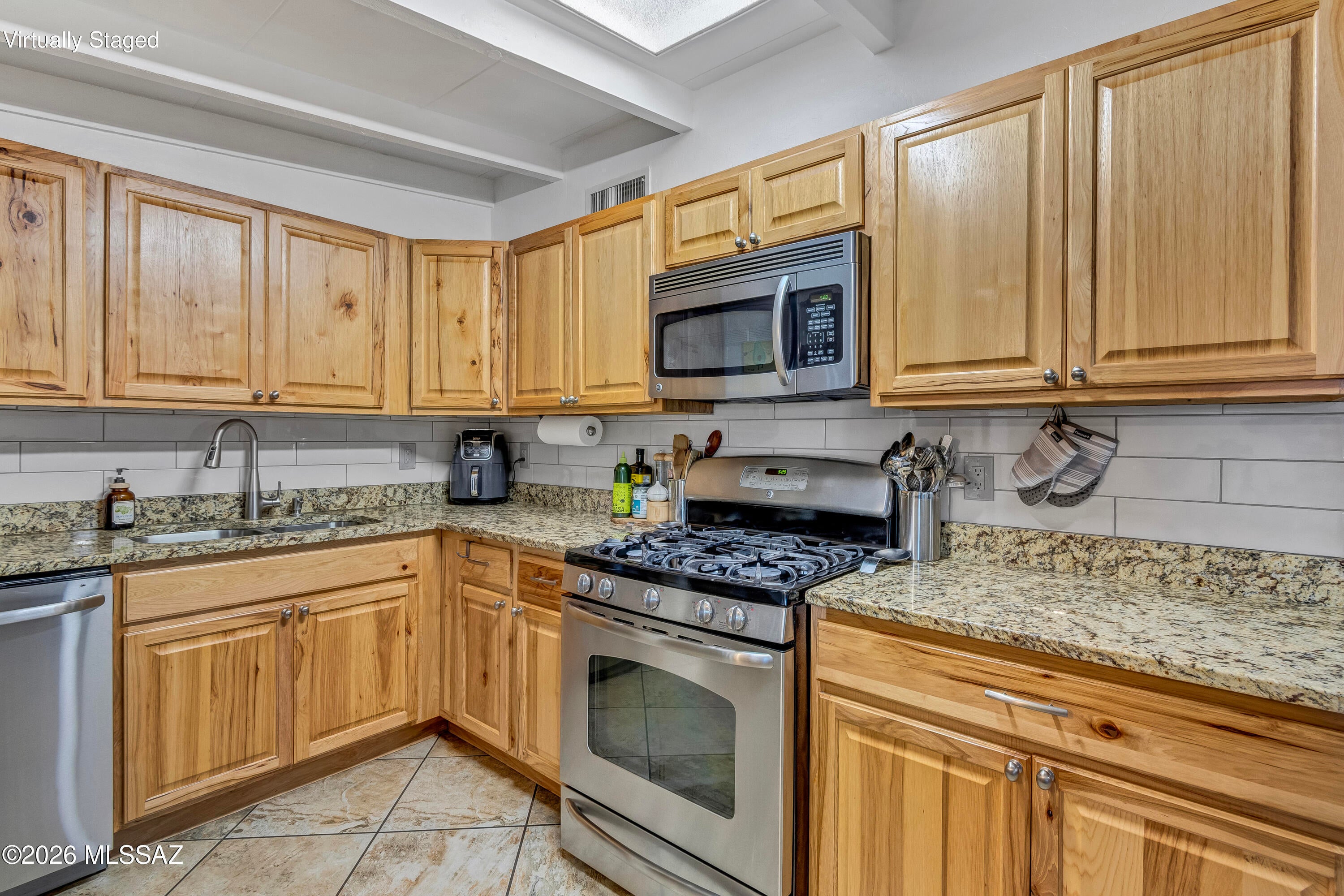 Beautifully remodeled 3-bedroom home with bright open living spaces and modern finishes throughout. The kitchen features granite countertops, stainless appliances, and custom cabinetry that flows into the spacious living area, Tile throughout the home, perfect for entertaining. Mature trees and manicured landscaping create a private backyard retreat, while multiple covered parking spaces and a garage provide rare convenience in this neighborhood. That's 4 covered parking spaces AND an enclosed Garage! Don't miss this gem
