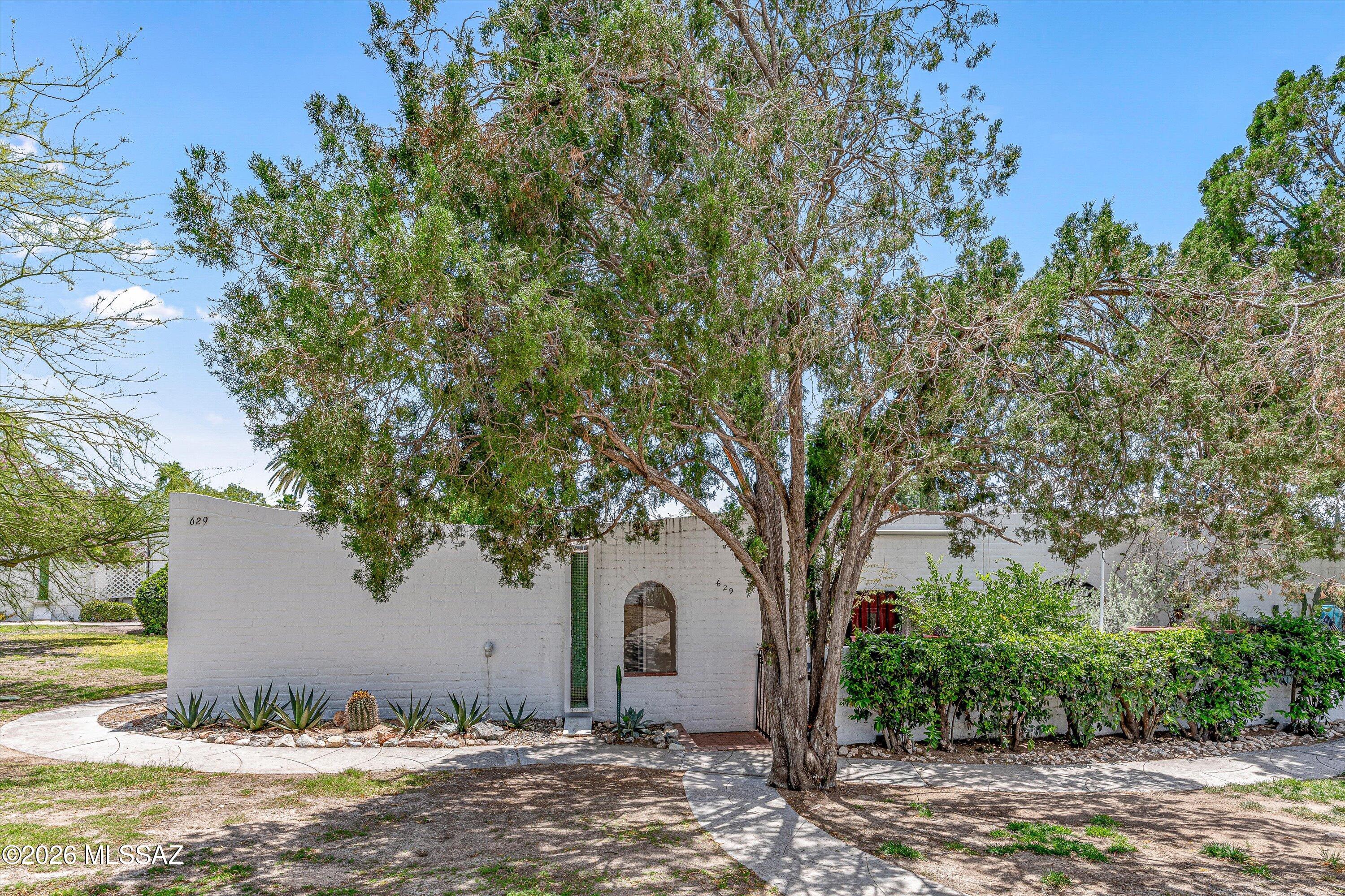 Discover historic charm in this 55+ condo community designed by renowned architect Bennie Gonzales. Casitas De Castilian is nestled on 17 lush acres off Oracle Rd & Roller Coaster.  This home features a new roof (2025), AC (2026), stainless steel appliances, brick flooring, a private patio, a carport, a storage unit, and a corner unit.  Enjoy significantly lower property taxes thanks to the community's beneficial historic designation. Amenities feature two pools (one heated year-round), a tennis court, & an active clubhouse.  HOA fee includes water, sewer, garbage, blanket insurance, streets, & building & grounds maintenance, offering a truly carefree lifestyle in a prime, desirable location.