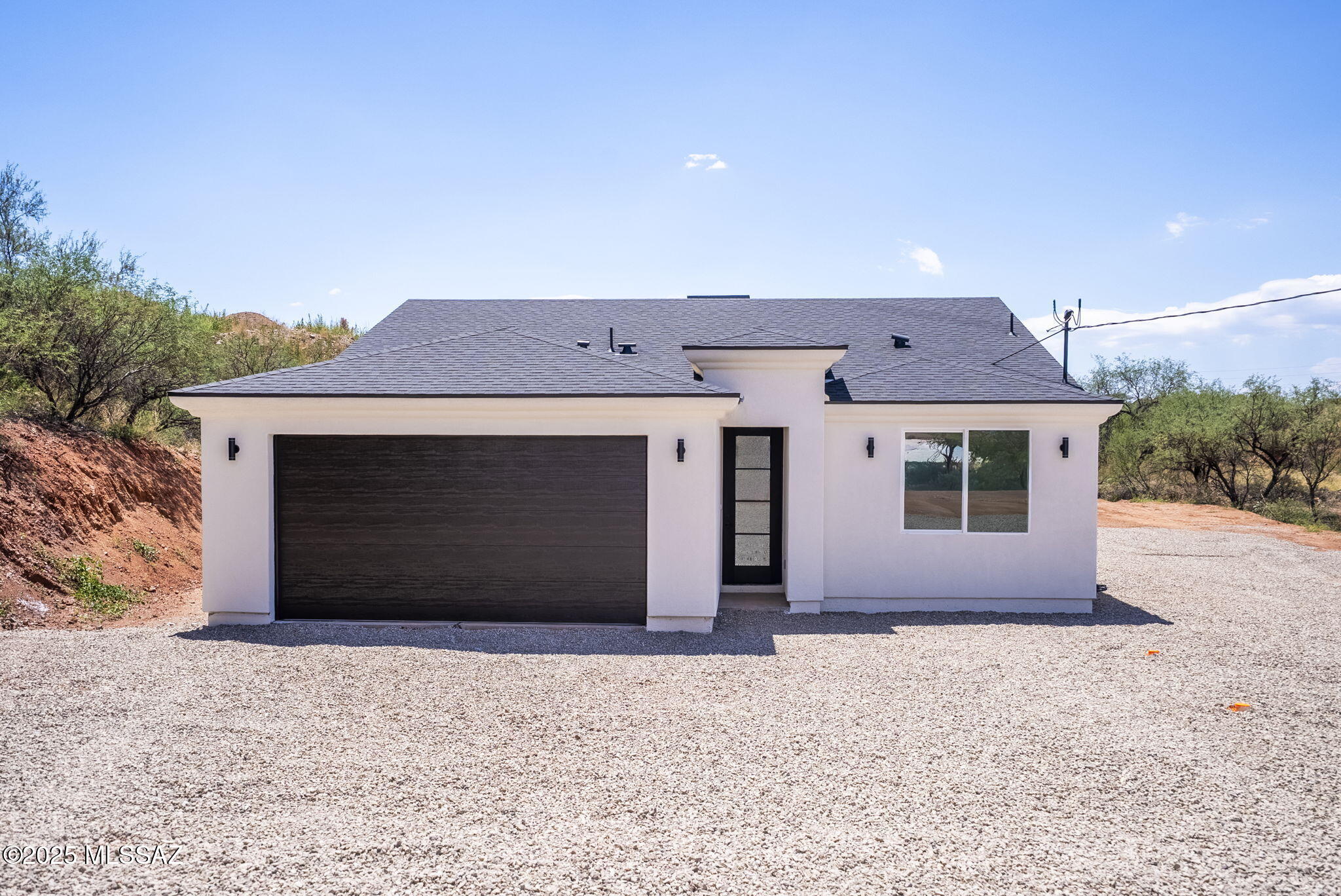 Currently being built. This beautifully crafted modern new construction home offers 1,464 square feet of thoughtfully designed living space. Located just minutes from I-19 via the Rio Rico Drive exit, this home combines convenience with contemporary elegance. Step inside to an open concept floor plan featuring ceramic tile throughout for a clean, cohesive look. The custom white kitchen is a true showstopper, complete with stainless steel appliances, soft-closing hinges, a spacious pantry, and stunning Level 2 granite countertops, all illuminated by modern light fixtures that elevate the space. The primary suite is generously sized, featuring a walk-in closet and a large tiled shower for a spa-like experience. The guest bathroom offers a dual vanity, ideal for family or visitors. Additional highlights include a dedicated laundry room, a covered patio perfect for outdoor entertaining, and a very usable lot ready for your personal touch. Constructed with upgraded stucco and topped with a sleek black double-layer shingle roof, this home blends style and durability in a desirable location.Don't miss the opportunity to own this move-in ready modern gem!