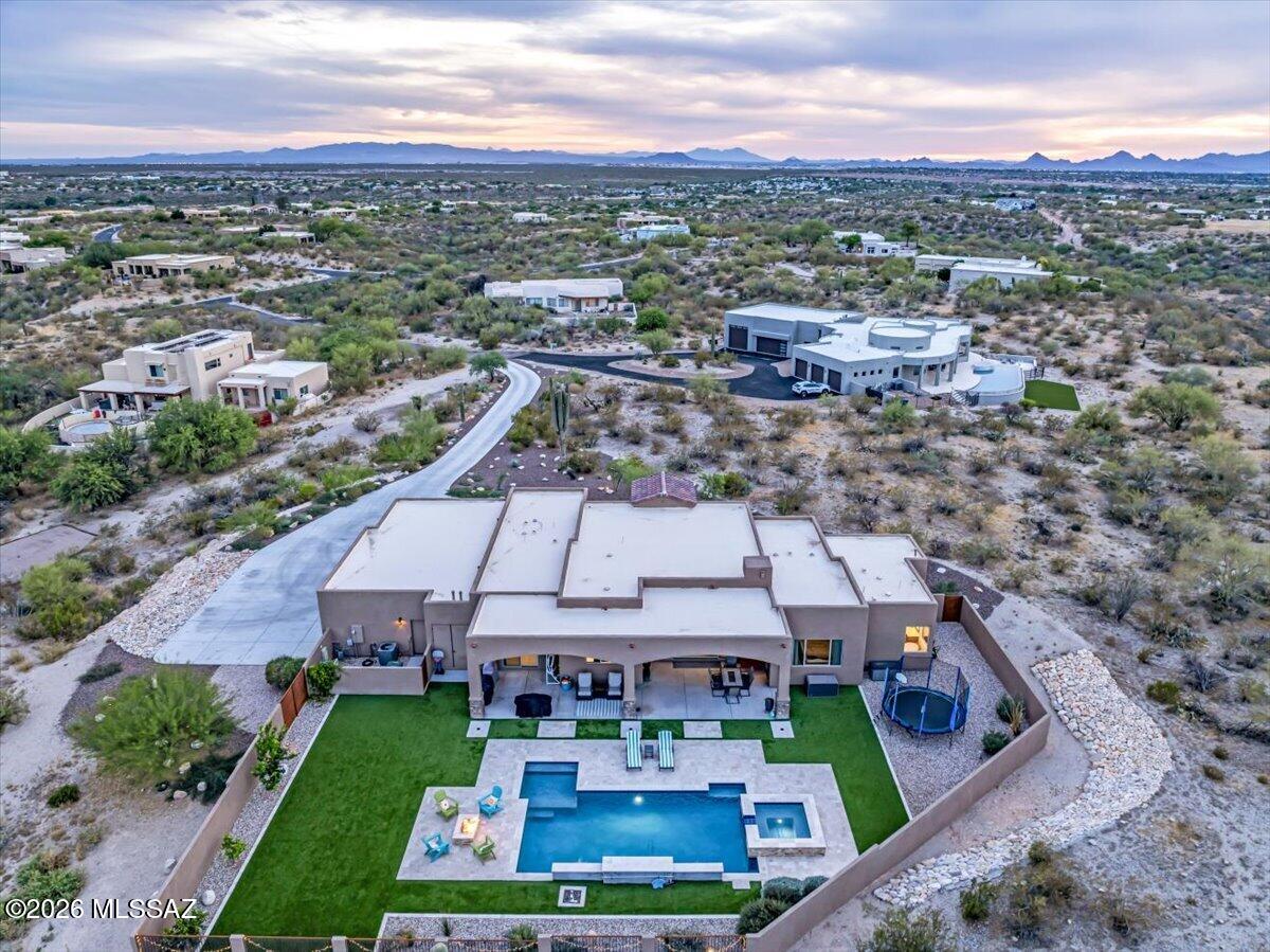 Experience elevated desert living in this exceptional luxury estate. Thoughtfully positioned to capture sweeping views & ultimate privacy, this residence offers a seamless blend of sophistication & serenity. You are welcomed by impeccable craftsmanship, soaring ceilings, & an abundance of natural light that highlights every curated detail. The expansive great room flows effortlessly into a custom kitchen outfitted with top-of-the-line appliances, custom cabinetry, designed for both entertaining & everyday living. The primary suite is a private retreat, featuring a spa-inspired bath & generous walk-in closets. Outside, a resort-style backyard designed for true Arizona living is complete with a sparkling pool, covered patio, and multiple seating areas.