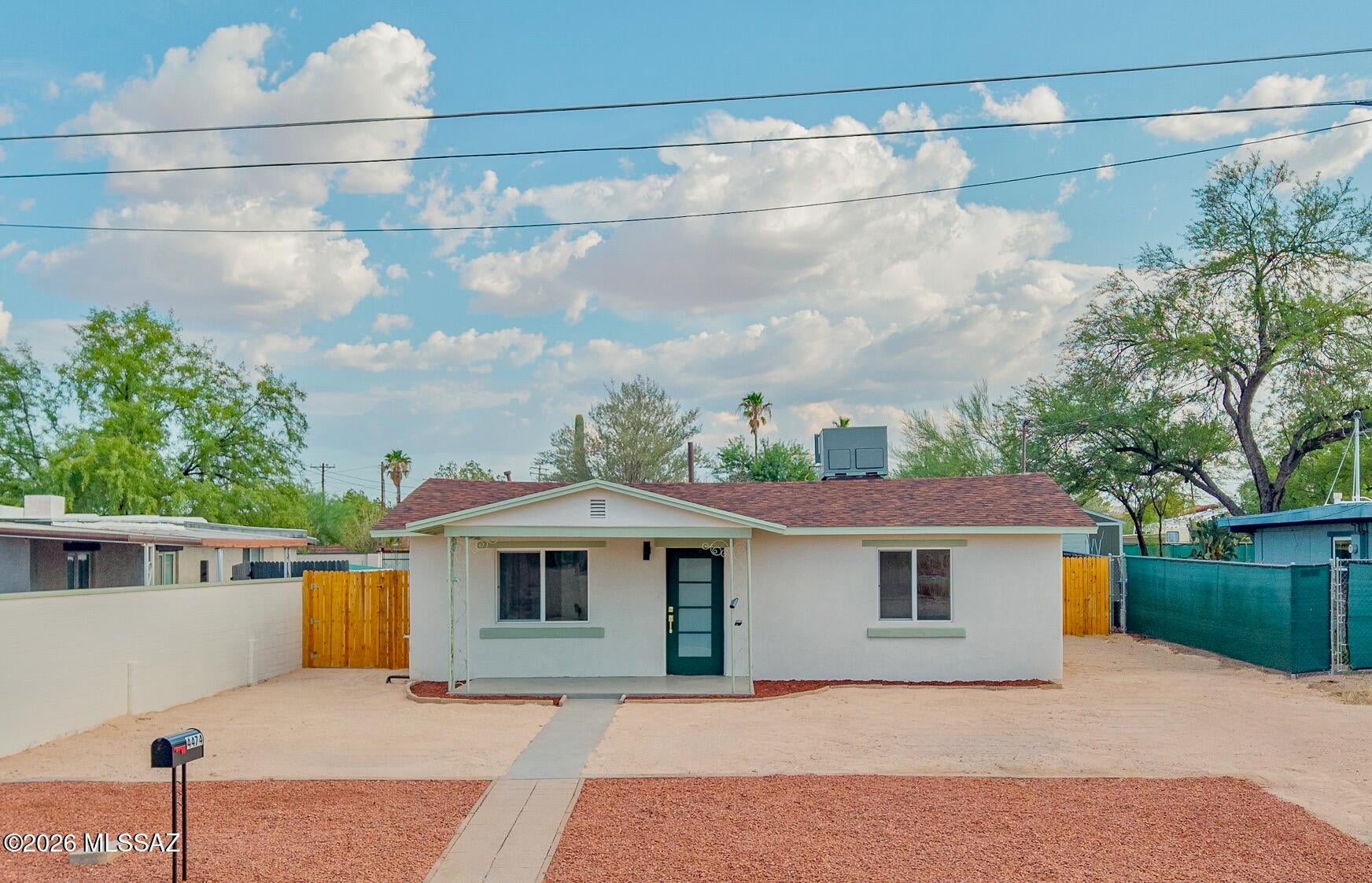 Seller to accept or counter offers between  $324,900 - $339,900. Beautifully remodeled and move-in ready! Warm stained concrete overlay flooring runs throughout, durable and easy to care. The kitchen boasts all-new light oak shaker cabinets, brushed gold hardware, granite counters, tile backsplash, and new stainless appliances, opening to a dining area with a pantry and laundry closet. Two fully redone baths: tub/shower combo in one, walk-in shower with mosaic detail in the other, both with new tile and granite vanities. Big front living room, recessed lighting, new ceiling fans, and new interior doors throughout. Fresh stucco and paint, new roof, covered front porch, and low-maintenance desert landscaping. Ample driveway parking out front, plus a carport and extra parking in back!