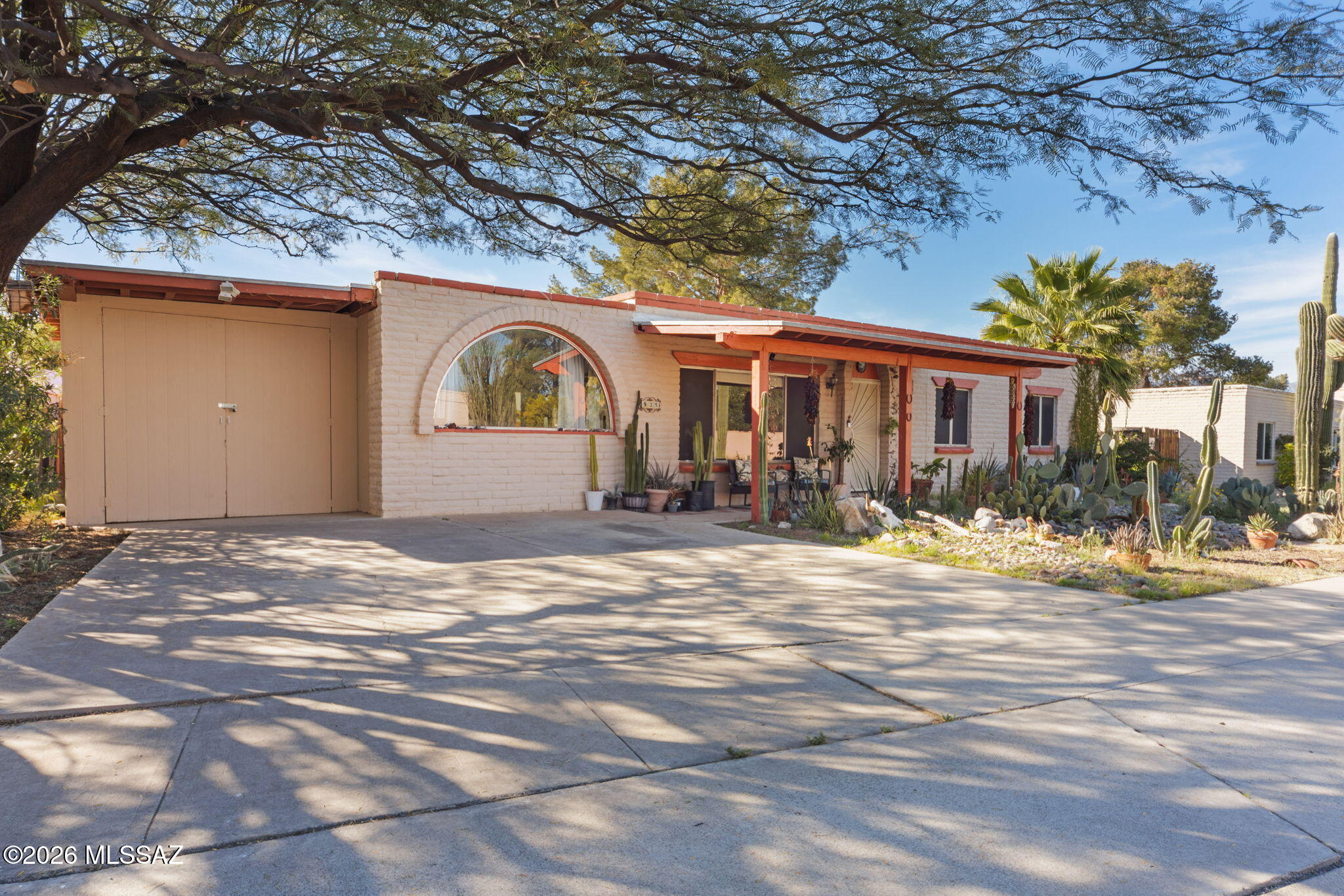 Classic mid-century ranch style home. Situated on nearly a quarter-acre lot, this home features: new pool pump (2024), newer hot water heater (2022) and HVAC (2020). Smart home features include Nest thermostat and Nest smoke alarms. No rear neighbors and no HOA, this home offers privacy and flexibility.  Enjoy sunset views from the enclosed Arizona room or relax on the spacious back patio overlooking the pool. Lush landscaping includes towering saguaros in front, and mature palm, citrus, and willow acacia trees in the back. Don't miss the extra large enclosed storage adjacent to the laundry room.  Saguaro National Park is just a 10 minutes drive away, and shops, restaurants and amenities are just up the road.