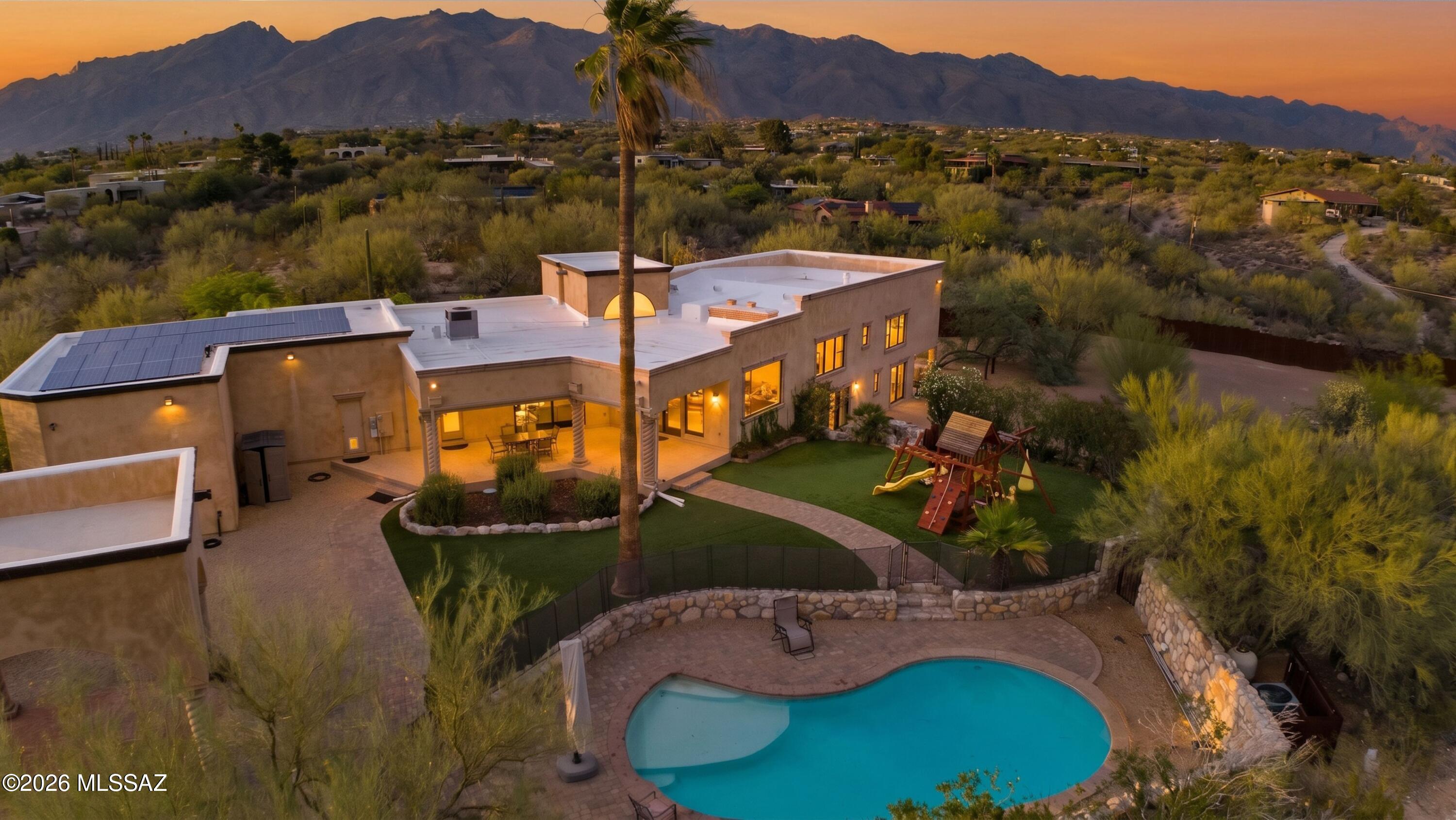 Experience quality craftsmanship in this adobe and stucco estate, thoughtfully remodeled by luxury custom home builder as his personal residence. Set on 1.63 horse-friendly acres in Tucson's Foothills, this 4,147 sq ft multi-level home captures majestic mountain views and sparkling city lights. The open floor plan features soaring ceilings, picture windows, 5 BR/ 4BA.  The gourmet kitchen showcases Viking appliances, a 6 burner gas range, double ovens, handcrafted cabinetry,  Cantera stone range hood & chiseled-edge granite countertops. The backyard is an oasis with an expansive covered patio. Enjoy a heated lagoon entry pool, ramada, fire pit, arena, tack room, hay storage, oversized 4-6 car/RV garage, mature landscaping & turf play area. Owned solar provides energy effeciency.