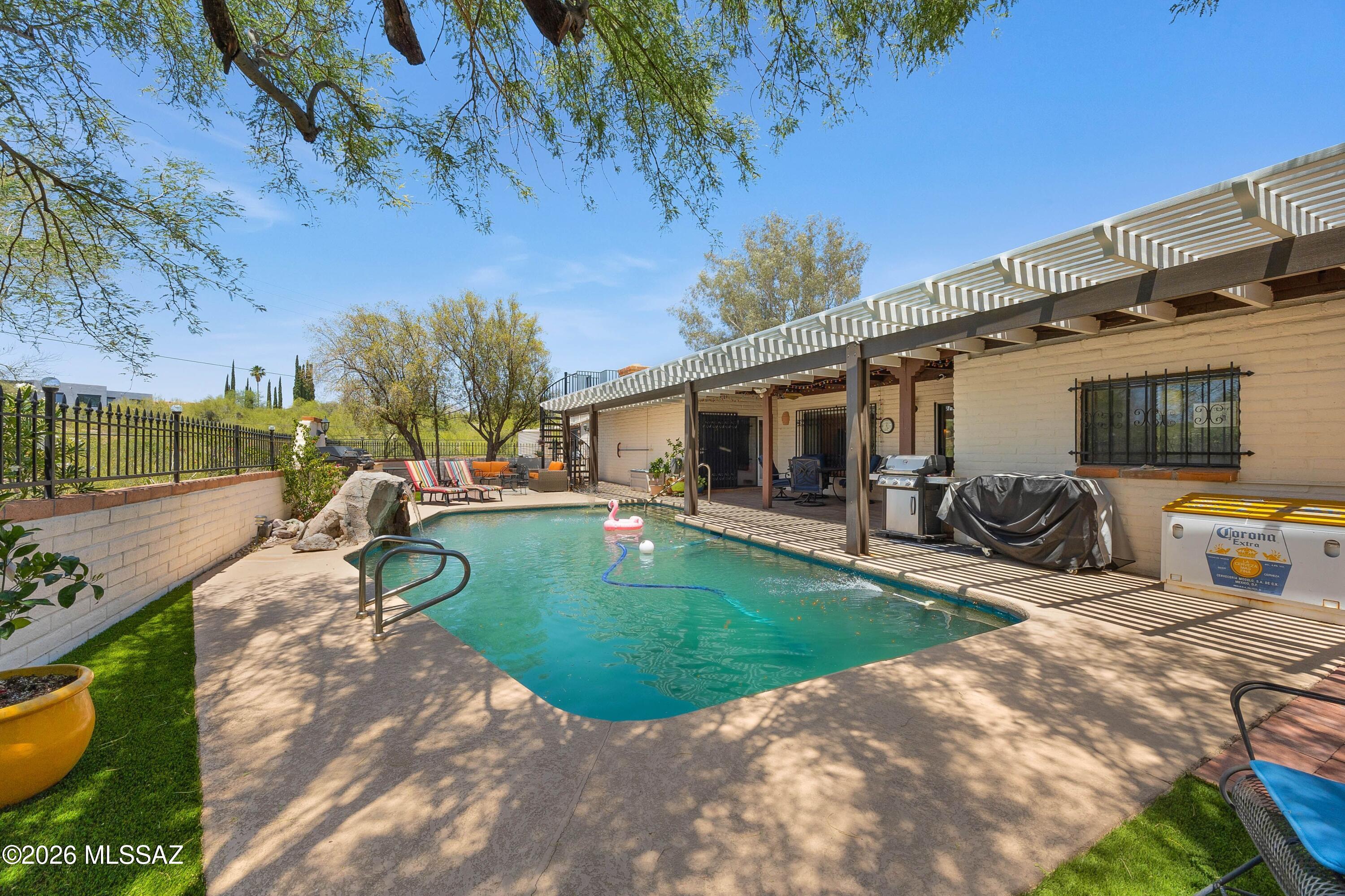 Price range listing. Seller will consider offers between 630-660k. Reduced.  Classic Southwestern burnt adobe territorial home on over 1.4 acres in the fabulous Catalina Foothills. Wonderful paver circular driveway. Versatile floor plan with open kitchen to large dining room, or family room with beamed ceilings and bee hive fireplace. Large windows showcase the mountain view. Saltillo tile throughout main living areas. Separate living room and dining area. Kitchen boasts granite counter tops, stainless steel appliances, raised panel wood cabinetry, electric range with double ovens and built in microwave oven. Full length covered rear patio overlooking the pool. Recently added turf. Three car garage, plus additional RV garage.