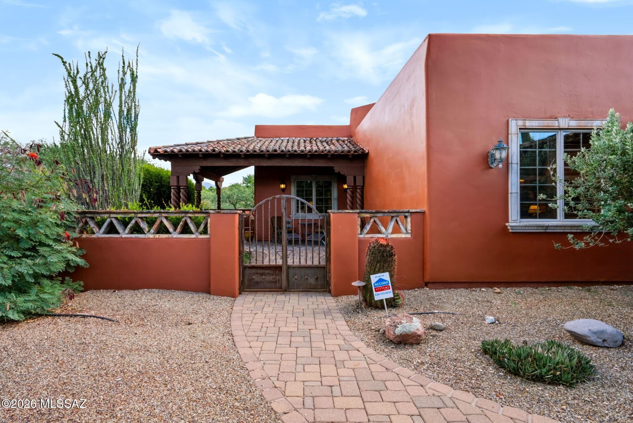 Fall in love with this inviting Tubac home, featuring thoughtfully designed spaces and a backyard made for unwinding. Sophisticated design elements include custom tilework, exposed beam ceilings, cozy fireplace and walls of windows that seamlessly blend exterior and interior. Separate den provides flexibility for home office, reading room or creative studio. Two bedrooms, each with its own private bathroom, offer comfort and privacy, while a convenient powder room accommodates guests. Triple-bay garage provides plenty of room for vehicles, storage and projects. Gated outdoor courtyard features mature shade trees, covered and open terraces, and a hot tub for relaxation. This is an ideal spot for al fresco entertaining and a tranquil setting for peaceful evenings under the Arizona sky.