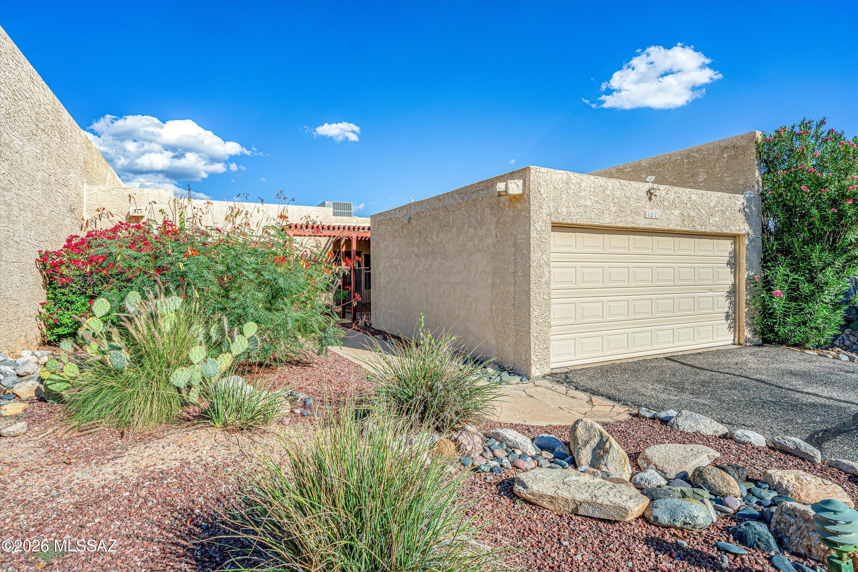 Nestled high up in the prestigious Catalina Foothills, this elevated serene corner townhouse sits toward the peaceful end of a street, offering an unparalleled blend of privacy and dramatic scenery. Infused with a rich southwestern ambiance, inspired by the natural desert landscape , this home delivers striking views of the mountains and desert from your back patio. Stepping through the charming courtyard, filled with Bird of Paradise and Bouganvilla blooms, you are greeted by an open great room design, featuring colored concrete floors and a romantic wood-burning   beehive  fireplace. The space flows effortlessly into a beautiful cook's kitchen, accented by beautiful native southwestern ceramic tile. Home is available vacant or fully furnished. Call Listing Agent for details! HOME HIGHLIGHTS: Living Space: Double door entry. Open concept greenroom with a romantic wood-burning beehive fireplace. Kitchen: Chef ready space featuring stainless steel appliances and beautiful ceramic tile details. Bedrooms: Private primary bedroom complete with an ensuite bathroom. Flooring: Low maintenance, colored concrete floors throughout the entire home. Parking: 2 car attached garage providing ample storage and convenience.  Community: Access to a sparkling pool and one block to the entrance of Skyline Country Club and Golf Course. The outdoor living space is a true sanctuary. The backyard patio serves as a front-row seat to spectacular mountain vistas and functions as a vibrant natural habitat, attracting a remarkable variety of native and migrating birds throughout the year, Whether you are looking for a peaceful desert retreat or an entertainer's dream, this foothills gem offers the ultimate Tucson lifestyle.