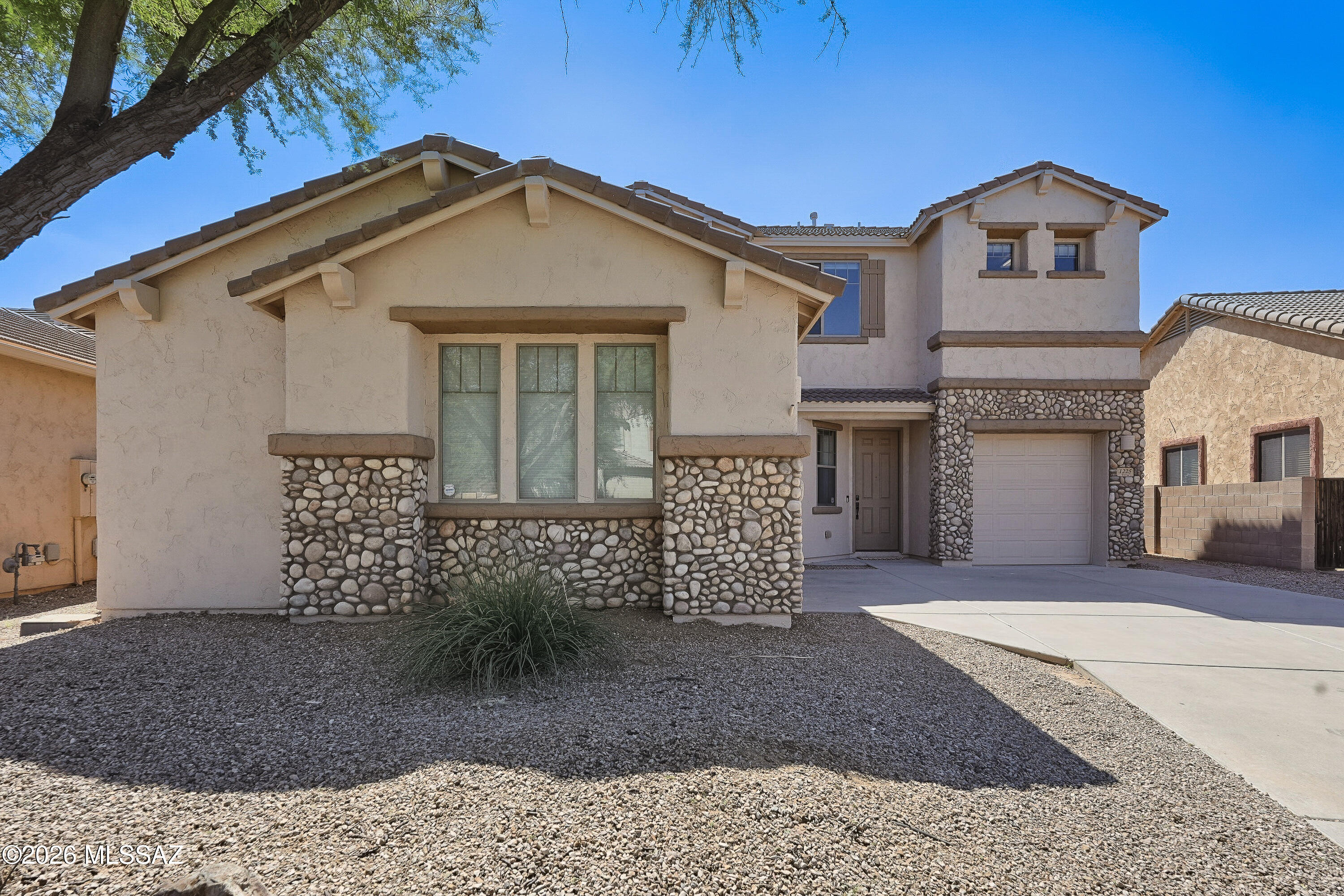 Meticulously maintained and showing like a model, this stunning 5BD/3BA+2Bonus Rooms+Pool and Spa+3 Car Garage+New Roof+New HVAC+New Windows (3,261sqft) two-story Oro Valley residence blends upscale comfort with exceptional day-to-day functionality. Arrive to a beautiful entry framed by elegant exterior stone accents, guiding you into a light-filled interior dressed in a fresh neutral palette. The open-concept main level offers a fluid layout connecting common gathering hubs with a premium culinary kitchen featuring solid quartz countertops, a massive preparation island, and a gas oven/stove. Designed masterfully for multi-generational living or overnight guests, the home features a highly sought-after first-floor bedroom and full bathroom downstairs. Ascend to the second story to find a massive bonus loft room, immense storage configurations, and an expansive primary suite retreat. The rear grounds are a true private desert oasis built for the ultimate resort-style outdoor living experience. Step out to an integrated covered patio layout to find a sparkling PebbleTec, saltwater pool with an in-floor cleaning system and an oversized spa. Surrounded by low-maintenance backyard, it serves as a spectacular venue for dining alfresco under the stars. Adventure enthusiasts and hobbyists will love the 3-car garage, complete with an upgraded, permitted electrical sub-panel in the separate single-car bay, making it the ultimate workspace or tool shop. Perfectly positioned in the heart of Oro Valley, you are just moments away from premier shopping, grocery stores, and local restaurants.