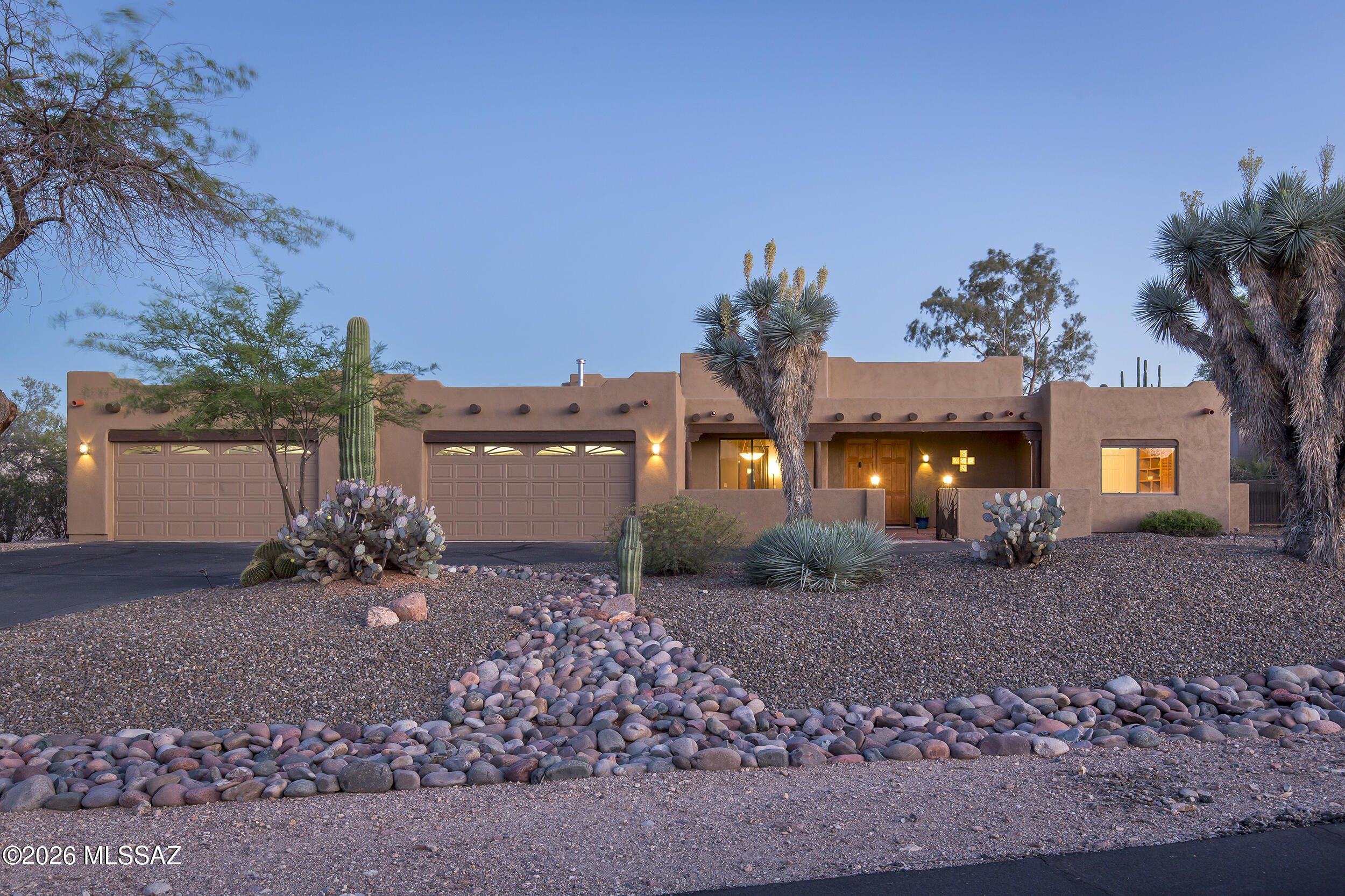 Located within the exclusive Los Arroyos Del Oeste gated community, this stunning custom Santa Fe home rests on a generous 1.14-acre lot, thoughtfully designed to embrace the beauty of indoor-outdoor desert living.

At the heart of the home, a dramatic great room impresses with soaring 14-foot ceilings and a classic kiva fireplace, flowing seamlessly into an open-concept kitchen appointed with granite countertops and a sunny breakfast nook. A separate formal dining room and an elegant built-in bar make entertaining effortless. The split four-bedroom floor plan offers both privacy and versatility for today's lifestyle.

The luxurious primary suite is a true retreat, featuring a soaking tub, separate shower, dual vanities, and a spacious walk-in closet -- all opening through sliding glas door to the outdoor oasis beyond. A fourth bedroom with its own separate entrance provides the perfect setting for guest quarters, a home studio, or a private office.
Step outside to a resort-caliber backyard built for unforgettable gatherings. A shimmering Pebble Tec pool and spa with a cascading waterfall set the stage, while a beehive fireplace, outdoor kitchen with built-in natural gas BBQ, and a sleek bar with polished concrete counters elevate every occasion. An expansive wood-beamed covered patio, multiple lounging areas, mature trees, stately saguaros, and a fully block-walled yard frame sweeping mountain views -- creating an authentic desert sanctuary unlike any other.

Completing this exceptional property is an oversized four-car garage offering abundant space for vehicles, storage, and all of life's extras.