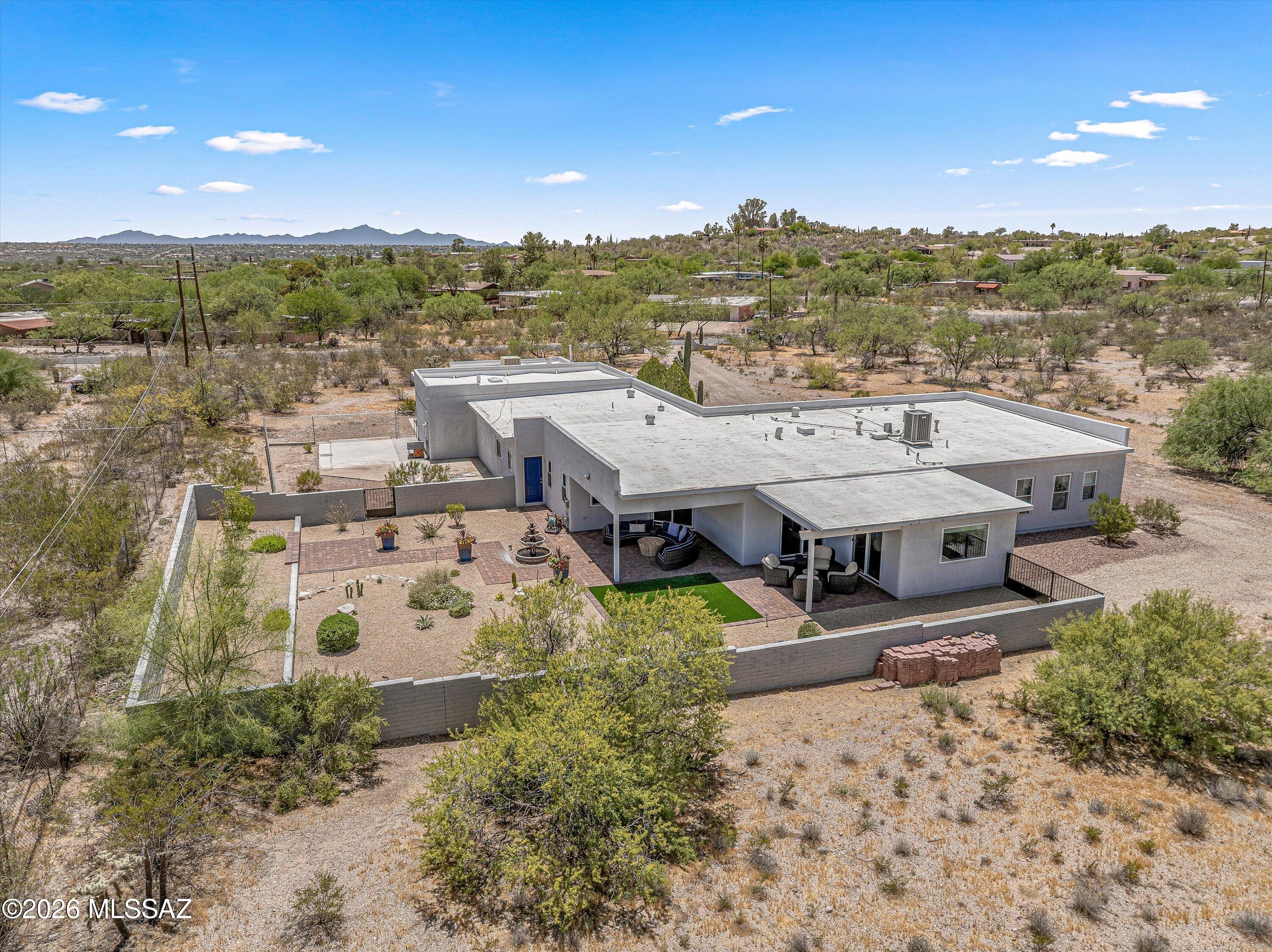 Price improvement! This Desert Gem on an irreplaceable 4.77-acre lot enjoys stunning Catalina & Rincon Mtn views & is in harmony w/ the natural setting. Thoughtfully upgraded & updated w/ quality, consistency, that reflects careful attention to detail throughout. Special focus & magic has been on the interior living spaces & backyard, creating a home that feels calm, inviting, & connected to its setting. Kitchen has quartz counters & high-end appliances including a Subzero fridge. LR has a quiet brightness w/ its north facing windows. Den/office sits off LR w/ mtn views. 3 BR's. 2 are ensuites & 3rd BR - potential to be guest quarters as part of the separate entrance hallway w/ a full bath. Approx 1600 sq ft garage would fit 5 + cars. Relax in the backyard watching the mtns. No HOA The home's refined interiors and thoughtfully landscaped backyard create a relaxed atmosphere, where indoor comfort and outdoor beauty come together effortlessly. The harmonious color palette, updated hardware, and modern finishes give the home a polished contemporary feel without losing warmth. Improvements have been made over the last 4 years. "New" it refers to improvements completed during that time frame.

KITCHEN
The kitchen is truly the heart of the home. Thoughtfully modernized with quartz counters, tile backsplash, stainless steel appliances, and a Sub-Zero refrigerator that is only a few months old. It blends function and quality. The kitchen also features a Bosch oven and microwave, gas cooktop with Thermador vent, pantry with deep pull-outs, and upper cabinets with glass doors and lighting. The breakfast counter creates a welcoming place to sit, visit, and watch the cook at work.

DINING, LIVING & OFFICE SPACES
Across from the kitchen, the oversized dining area is designed for gathering. With windows on two sides, it has a bright, open feel and easily becomes one of the favorite spaces in the home.
The spacious living room offers a quiet brightness from its north-facing windows. Just off the living room, a den/office captures mountain views and provides flexible space for working from home, reading, hobbies, or simply enjoying the peaceful setting.
Bedroom Suites & Flexible Guest Space
The primary suite feels like a private retreat. North-facing windows with up/down shades bring in soft natural light while maintaining privacy. The suite also includes a walk-in closet and a spa-inspired bath with dual sinks, granite counters, a free-standing soaking tub, heated toilet and bidet, and a separate oversized shower with modern subway tile surround, niches, and frameless glass doors.
The second bedroom lives like a second primary suite, with an adjoining bath finished with marble flooring, granite countertop, quality hardware, and an oversized shower with subway tile surround, niches, a built-in seat, and frameless glass shower doors with modern exposed hanging hardware.
The third bedroom offers excellent flexibility and has strong potential as guest quarters. This area includes a separate entrance into the hallway, a bedroom, and access to a full bath equipped with a walk-in jetted tub. It is a practical and thoughtful layout for guests, extended stays, multigenerational living, or private workspace needs.

GARAGE AND WORKSPACE
The approximately 1,600 sq ft garage is an exceptional feature. With room for five or more cars. It offers space rarely found in a traditional residential property. The garage is heated and cooled with a newer evaporative cooler, has insulation in the ceiling, many skylights, high ceilings in the main area, three distinctive work or storage areas, and three roll-up garage doors, including one 8-foot door.

OUTDOOR LIVING & SETTING
Outdoors, the backyard becomes a sanctuary. Two covered patios frame stunning views of the Catalina and Rincon Mountains, creating a beautiful setting for morning coffee, evening sunsets, entertaining, or quiet relaxation. The professionally landscaped yard was designed to feel tranquil while remaining easy to care for. A large, fenced dog yard is separate from the main outdoor living space.
The property is located on a small section of Fort Lowell that is only a few homes long, giving it a quieter and more private feel. The 4.77-acre lot is zoned for horses and offers rare flexibility. The property was also previously approved as a cat sanctuary, and that business had not been started, which may be of interest to a buyer looking for unique live/work or animal-related possibilities.

PEACE OF MIND IMPROVEMENTS
Important peace-of-mind improvements have also been completed, including a newer roof, newer Lennox HVAC system, and newer Ruud water heater. Combined with the thoughtful interior updates, extraordinary garage space, mountain views, acreage, and no HOA, this home offers a rare blend of comfort, privacy, flexibility, and Tucson beauty.

Seller has now found new home and is motivated!