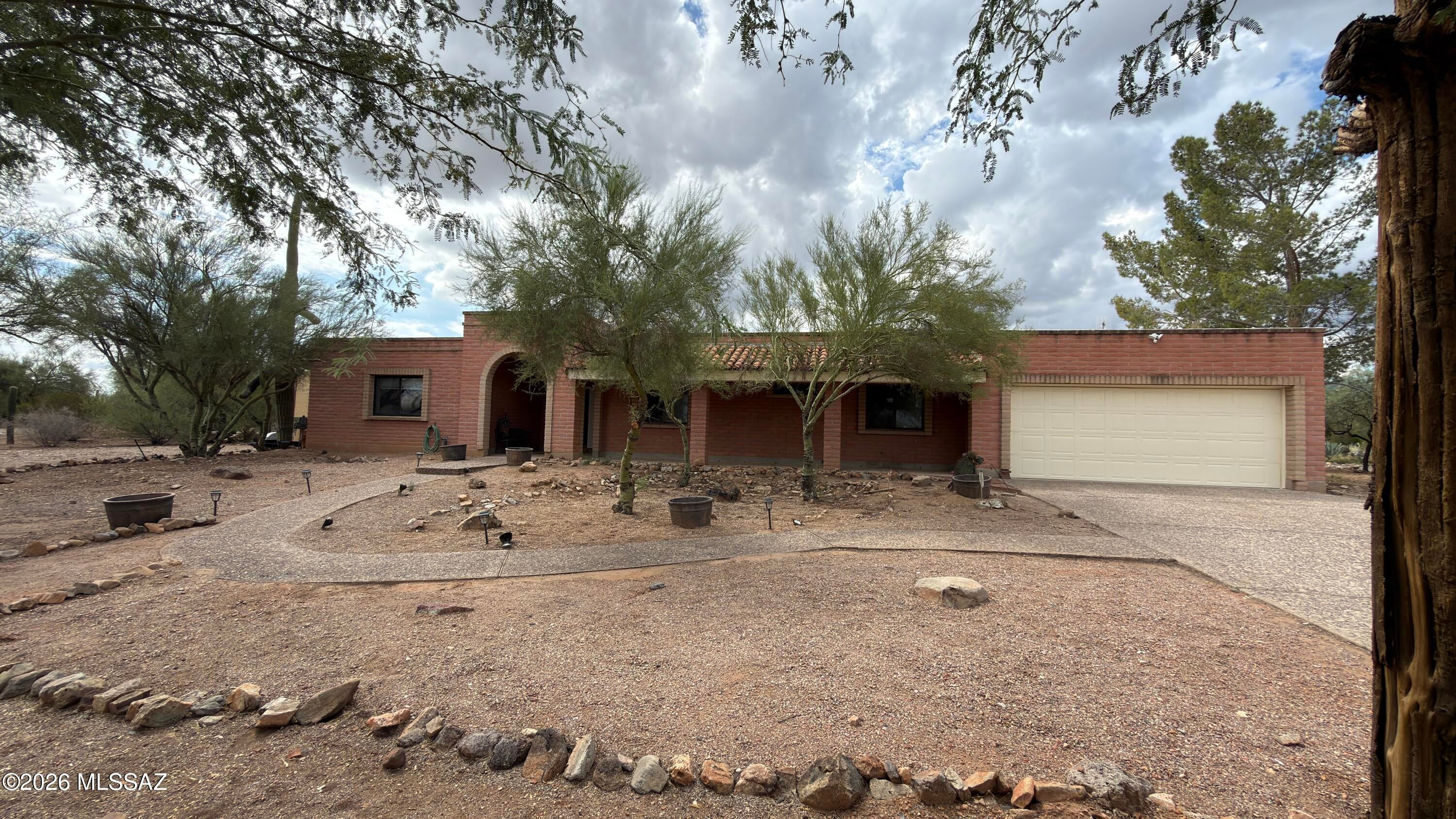 Set on a desirable 1.15 acre lot with no HOA and room for horses, this property offers space, privacy, and true Arizona living. This home features 2,714 square feet with 4 bedrooms, 4 bathrooms. 
 The land features beautiful natural desert landscaping with mature trees and saguaros, plus a fully enclosed backyard with both a side gate and double gate access. Outside, enjoy the sparkling pool surrounded by brick pavers, a raised patio for lounging, a large grass turf area and includes gutters that feed into two water cisterns. 
The property offers exceptional parking and storage: Slump block construction with an oversized 2 car garage that features an attached workshop, a detached 2 car carport, plus covered RV parking. The long aggregate driveway allows for additional parking. There's plenty of room for all your toys--bring your boat, RV, or even your horses! You are greeted with an oversized front covered porch with an arched entryway.
The spacious foyer opens to the living room with a wood burning fireplace. Ceiling fans and wood cased doorways throughout, plus a custom barn door in the formal dining room. The kitchen includes a breakfast nook, abundant cabinetry, and opens to the family room (or dining room!). Two sets of French doors lead to the enclosed Arizona room, complete with wood plank ceilings, Anderson windows that overlook the pool in the backyard, ceiling fans, and a convenient powder bath--perfect for those pool days! The primary suite features a walk in closet, ceiling fan, double sink vanity with updated brushed nickel fixtures, and a beautifully remodeled shower with decorative tile, pebble flooring, and dual shower heads. Two additional bathrooms have been fully remodeled with custom wood cabinetry, quartz countertops, modern lighting, decorative tile surrounds, and thoughtful storage. A spacious laundry room adds even more convenience.
Additional features include:
Water softener
Roof recently recoated with warranty
