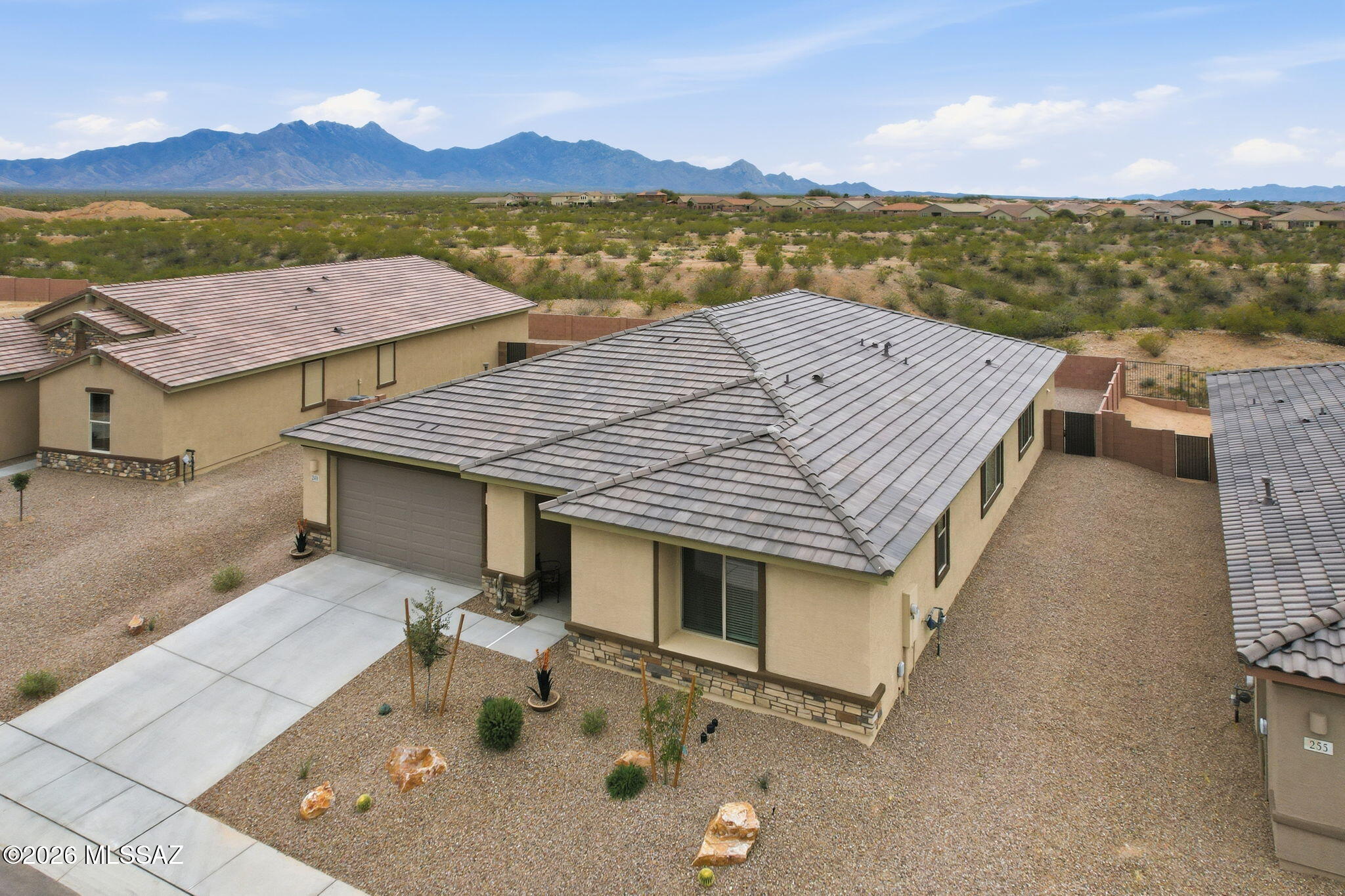 Built with precision and designed for the way people truly live, this newly constructed Meritage Palo Verde floor plan delivers space, efficiency, and style inside a private gated neighborhood with sweeping mountain and cityscape views.

Offering 4 bedrooms and 3 full bathrooms in a thoughtfully designed split-bedroom layout, this home balances privacy with open-concept living. From the moment you step inside, wood-look tile flooring guides you through light-filled spaces enhanced by abundant LED recessed lighting and custom ceiling fans throughout. Plush carpeted bedrooms provide warmth and comfort where it matters most. At the heart of the home, the expansive kitchen is built to impress and perform. A large granite center island anchors the space, surrounded by 42-inch cabinetry, coordinating backsplash, Whirlpool appliances including built-in cooktop, oven, and microwave, plus reverse osmosis for pure, clean drinking water. With not one--but two--pantries, storage will never be a concern. The flexible office/den offers versatility for a home office, creative space, or formal dining area depending on your needs. The spacious laundry room includes cabinetry and a utility sink for added convenience.

The primary suite is a true retreat, featuring a beautifully tiled walk-in shower and custom organization in the walk-in closet. Guest bathrooms offer dual vanity sinks, making busy mornings effortless. Two of the walk-in closets include custom organizational systems for elevated functionality.

Practical upgrades elevate everyday living: soft water system, fire suppression sprinkler system, and a 3-car tandem garage with professionally epoxy-coated flooring.

Step outside to panoramic mountain and city views. The backyard has been newly finished with decorative rock, creating a clean, low-maintenance foundation--an open canvas ready for your custom outdoor oasis.

Still covered under the builder's warranty, this home offers the confidence of new construction without the wait. Absolutely stunning, impeccably maintained, and ready for its next chapter.