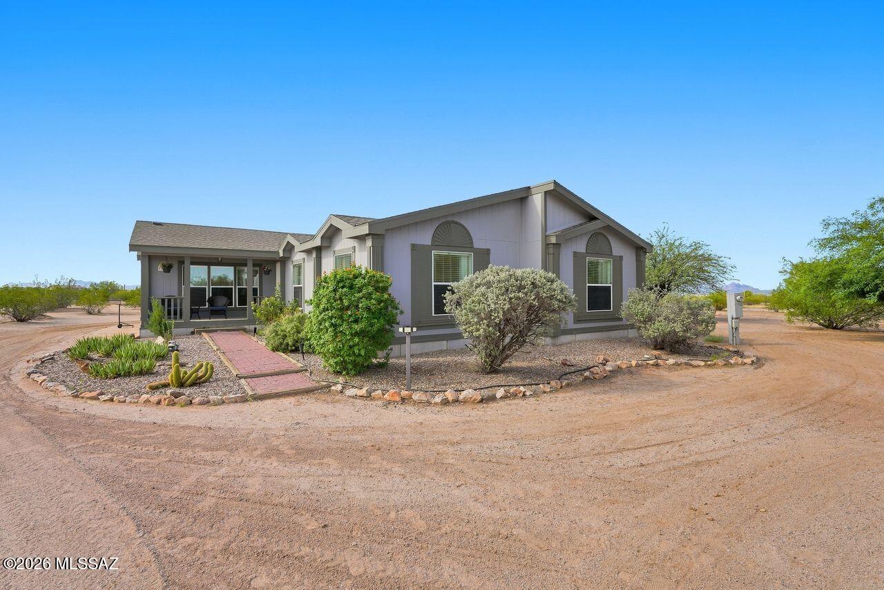 Country living at its finest! Set on approx. 4 fully fenced and beautifully landscaped acres backing to BLM land, this inviting 3BR/2BA home with den offers approx. 1,927 sq ft of bright, comfortable living surrounded by mountain views and wide-open Arizona skies. Sip your morning coffee from the cozy front porch and enjoy the peaceful desert setting. Inside, you'll find a spacious living room, generously sized bedrooms, and an impressive walk-in closet. Outside, there's room to breathe, explore, and enjoy the country lifestyle, plus a large shed/shop for hobbies, storage, or projects. Fresh exterior paint 8/25, AC replaced 2020, and new roof 8/26. Privacy, space, beautiful desert surroundings, and BLM land right out back make this property truly special! This is HOME!