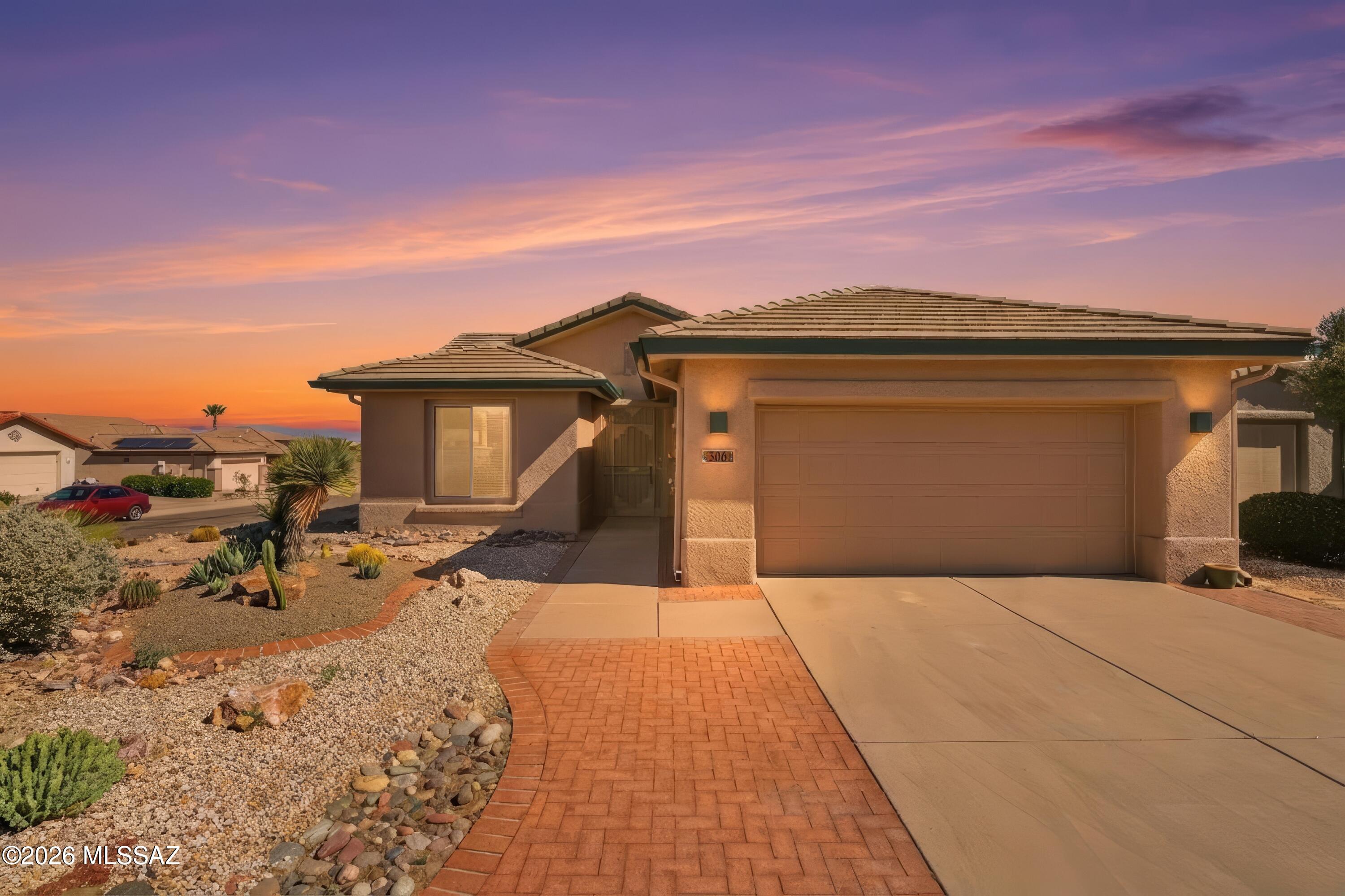 This quiet comfortable home is centrally located and thoughtfully designed for easy living. Situated on a corner lot, it offers patio living with magnificent views of the Santa Rita Mountains. It is also located within a five-minute walk of the West Desert trails.  A welcoming entryway opens to a light-filled great room featuring Southwest colors and beautiful stained glass accents throughout. The kitchen offers beautiful newer stainless steel appliances and easy-care countertops with a convenient dining area and bonus office space just off the kitchen.  The spacious primary suite offers a relaxing retreat with large bay window and generous closet space while a versatile second bedroom features an attractive Murphy bed with pull-down workspace-perfect for guests or hobbies.  Practical Practical features include a well-equipped laundry area with Whirlpool washer and dryer, utility sink, ample garage storage.

Multiple outdoor settings invite you to enjoy scenic mountain views, rolling cloudscapes, a spacious yard, and a large covered patio. An added bonus is a 500-gallon rainwater collection system designed to assist with watering needs. In addition, there is an owned Solar system keeping the bills low.  This lovely home offers a rare blend of charm, functionality, and low-maintenance living.