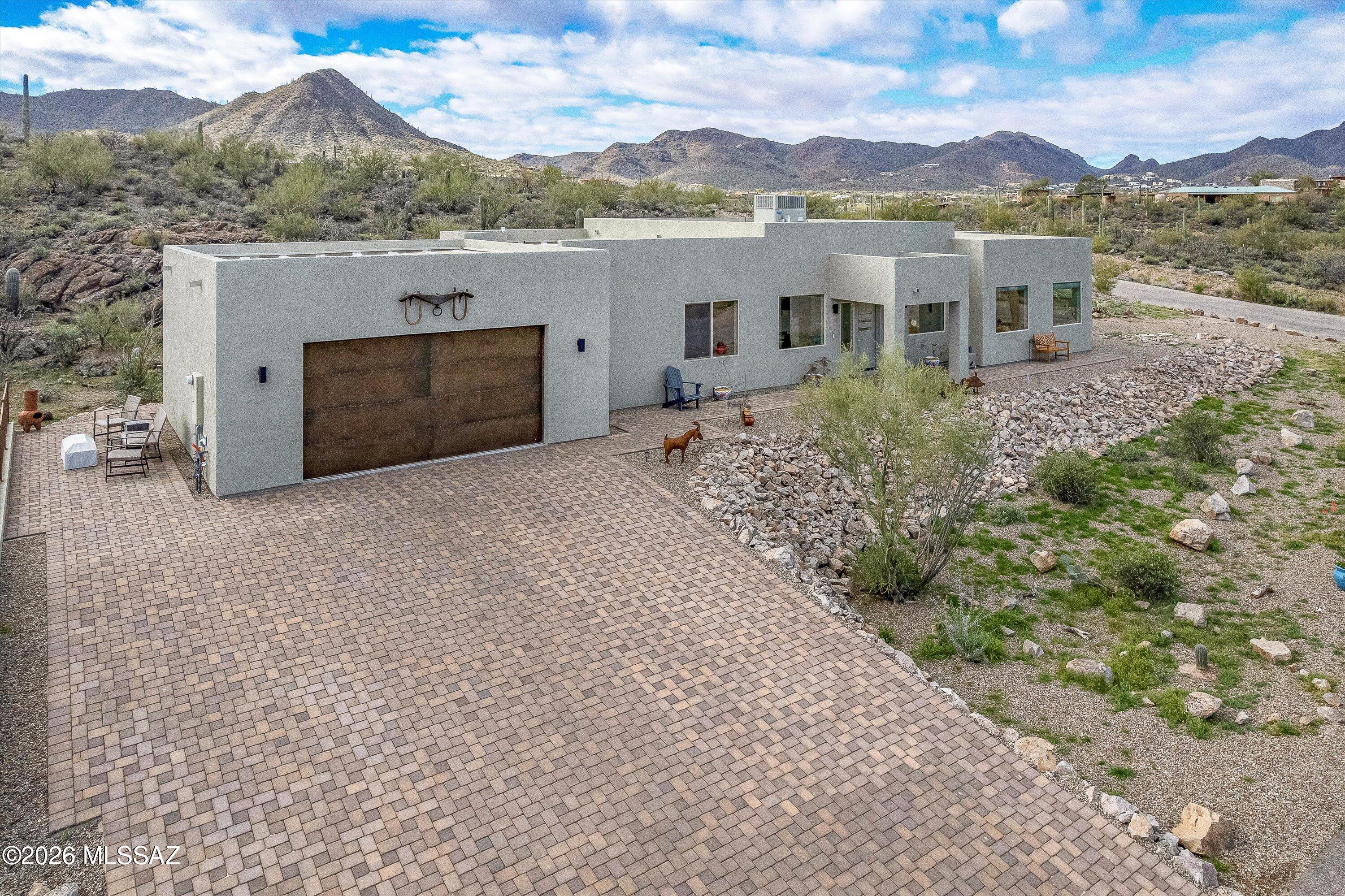 Built in 2025, this gorgeous 3/ 2 home offers the very best of modern desert living in Enclave at Gates Pass. One of Tucson's most breathtaking scenic overlooks, set against the stunning backdrop of Tucson Mountains. From the moment you arrive, you'll be captivated by sweeping Sonoran Desert views and unforgettable sunsets right outside your door. Thoughtfully designed with an open-concept floor plan, the home features a spacious great room filled with natural light, high ceilings, and seamless indoor-outdoor flow--perfect for entertaining or simply enjoying the peaceful desert surroundings. The modern kitchen showcases stylish finishes, ample cabinetry, and a large island ideal for gathering. The private primary suite provides a serene retreat with with a well-appointed En-suite bath and generous closet space. Quality craftsmanship and energy efficient construction ensure comfort and peace of mind for years to come. Enjoy the beauty, privacy, and endless outdoor recreation opportunities of the Tucson Mountains while remaining just minutes from shopping, dining, and downtown Tucson. Come see this exceptional home in person and experience the lifestyle that makes this one of Southern Arizona's most scenic and sought-after communities--you won't want to miss it.