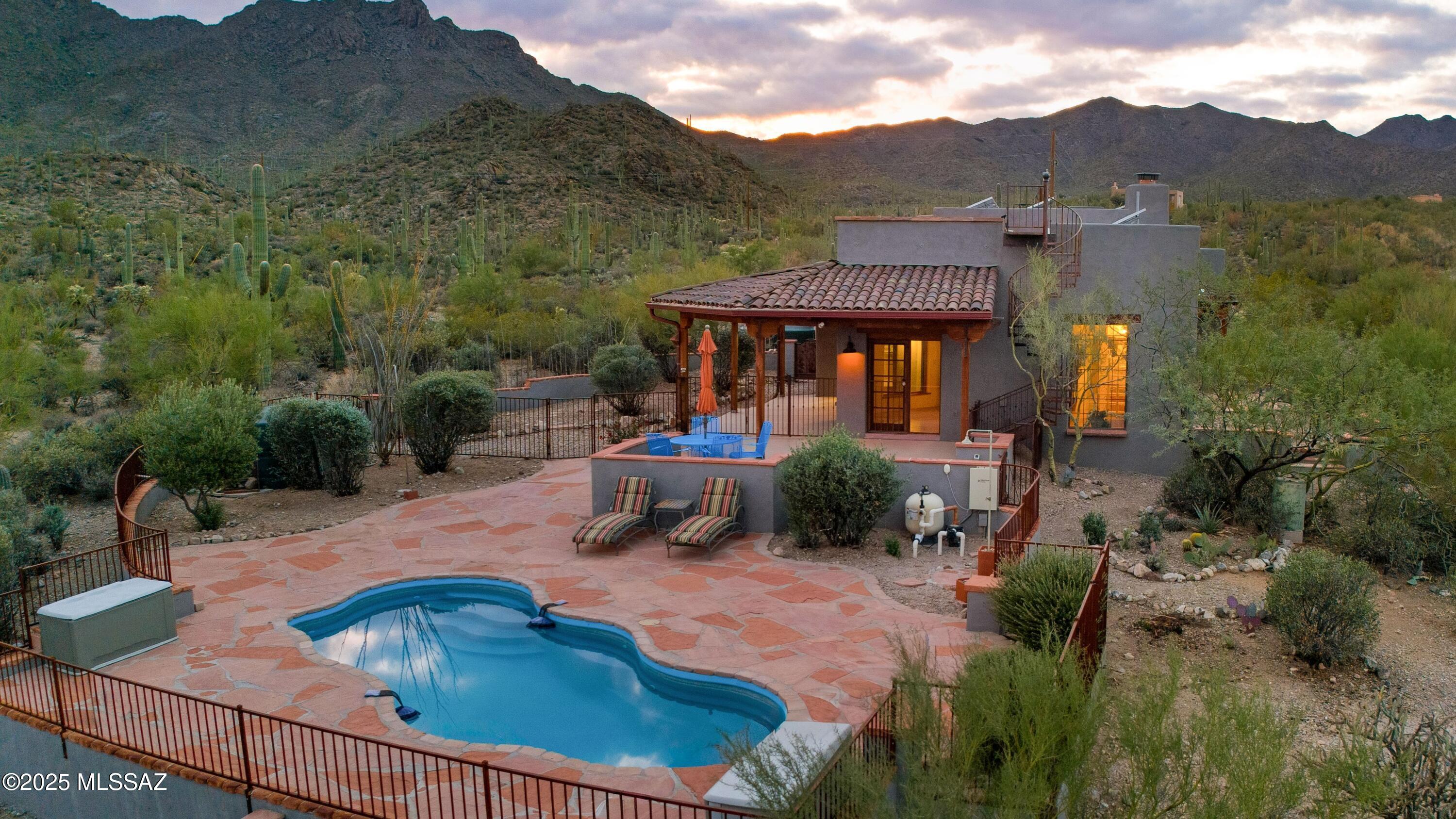 Welcome to this amazing home nestled in the Sonoran Desert with privacy, saguaros galore & a chance to live harmoniously with the gorgeous natural environment on 6.7 Tucson Mtn acres. This 4 bedroom, 3 bath home with scored concrete floors & private split floorplan has been lovingly maintained & that is abundantly obvious. Two primary suites with one that has it's own separate entry & perfect for MIL suite, private office.  This stunning home is set far off the road & hunkered into the desert with a sparkling pool, outdoor shower & rooftop deck to capture the most incredibly epic views of Tucson sunsets, sunrise & multiple mountain ranges. Owned solar, private well share with 1 other property plus extensive rainwater harvesting allow for nearly off grid living.Walk to Sweetwater Preserve!