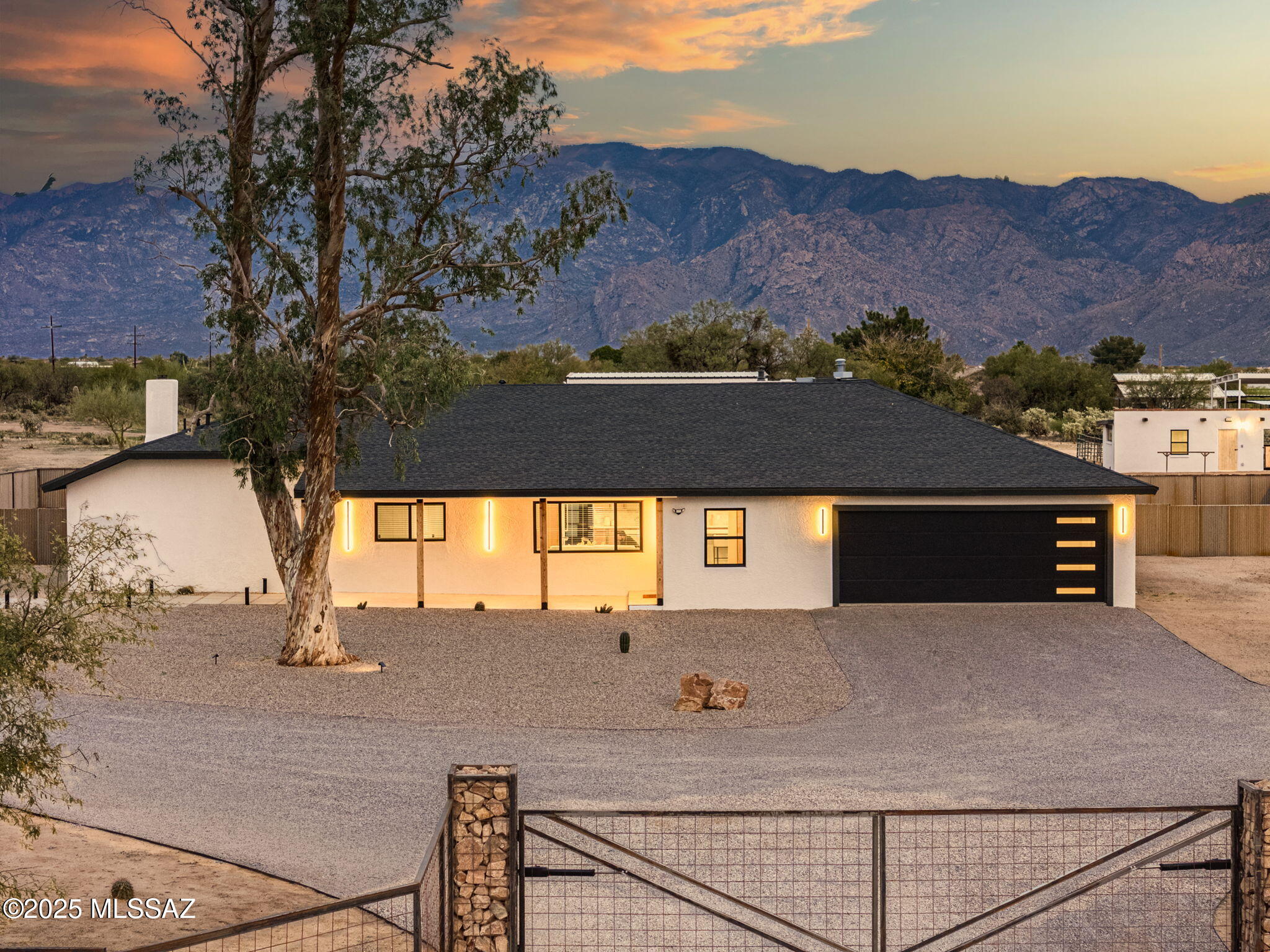 Experience classic Sonoran Desert living in this completely renovated ranch-style home set on 9+ expansive acres in coveted Oro Valley. Located near La Cholla Airpark, this exceptional horse property offers a rare balance of privacy, tranquility, and everyday convenience. It is minutes from shopping, dining, and amenities, yet offers the peaceful feel of true country living. Framed by breathtaking panoramic views of the Catalina Mountains and Pusch Ridge, the property invites you to slow down and savor the natural beauty that surrounds you. Enjoy sunrise coffee on the back patio, or sunset evenings from the expansive front porch, where open skies and desert serenity stretch in every direction. With abundant usable acreage, the possibilities are endless and perfect for equestrian use, additional structures, or future expansion. The grounds feature horse stables, ample space for riding and training, gabion pillar fencing, a 2-bay RV garage, and an additional 4 bay carport, making this property as functional as it is picturesque. The newly replaced roof is finished with Timberline algae-resistant architectural shingles, adding both durability and peace of mind.
Inside, the home has been thoughtfully and extensively reimagined with a reconfigured floorplan and raised ceilings, creating a bright, open, and welcoming atmosphere. All-new interior drywall and Sherwin-Williams designer paint provide a clean, modern backdrop, complemented by new doors, updated lighting, and contemporary fixtures throughout.
Comfort and efficiency were prioritized with new dual-pane windows, smart thermostats, a new garage door, and a fresh epoxy-coated garage floor. Every detail reflects quality craftsmanship and intentional design. At the heart of the home, the chef's kitchen is a true statement space, featuring solid wood custom cabinetry with dovetail drawers and soft-close hardware, a dramatic honed Matarazzo Quartzite waterfall island, and a complete suite of Thor appliances -- perfect for both daily living and entertaining. The floor plan flows seamlessly into the main living area, anchored by a striking Empire Loft 46" millivolt vent linear natural gas fireplace, enhanced with Woodupp wood slat accents that add warmth, texture, and architectural interest. A wet bar rounds out this gathering area. The property is supported by a private well and a propane tank. This is a truly rare Oro Valley gem, offering a turnkey, extensively upgraded ranch home on acreage, ideal for horse enthusiasts, aviation lovers, or anyone seeking space, views, and serenity, all while remaining conveniently connected to everything the Tucson area has to offer.