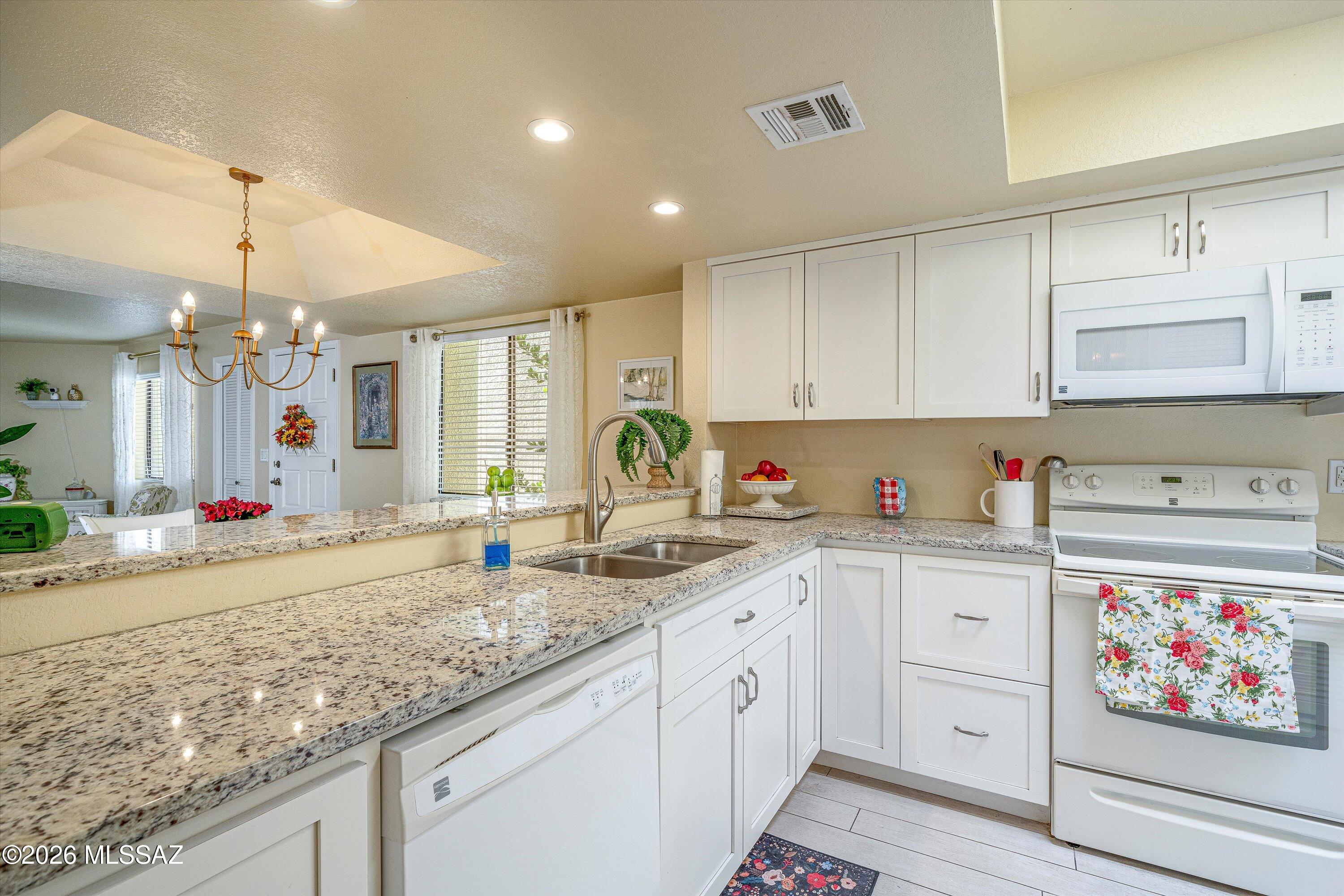 Tucked inside a gated 28-unit community near Oro Valley, this 2BR/2BA spilt floor plan is updated and spacious. Custom cabinetry, granite countertops, skylights, split bedroom plan, walk-in closets, and a new HVAC system (2023). The 2-car attached garage with direct interior access is rare for the community. No interior steps. Cute covered private patio for your private garden. Low-maintenance living in a secure, beautifully landscaped enclave with mature trees and fountains. The HOA handles the exterior, a sparkling community pool, spa, and shaded ramada. For the buyer who wants less to manage and more to enjoy, whether that's year-round or seasonally, this one delivers! Seller is receptive to thoughtful offers, presenting an opportunity for buyers to make this property their own.