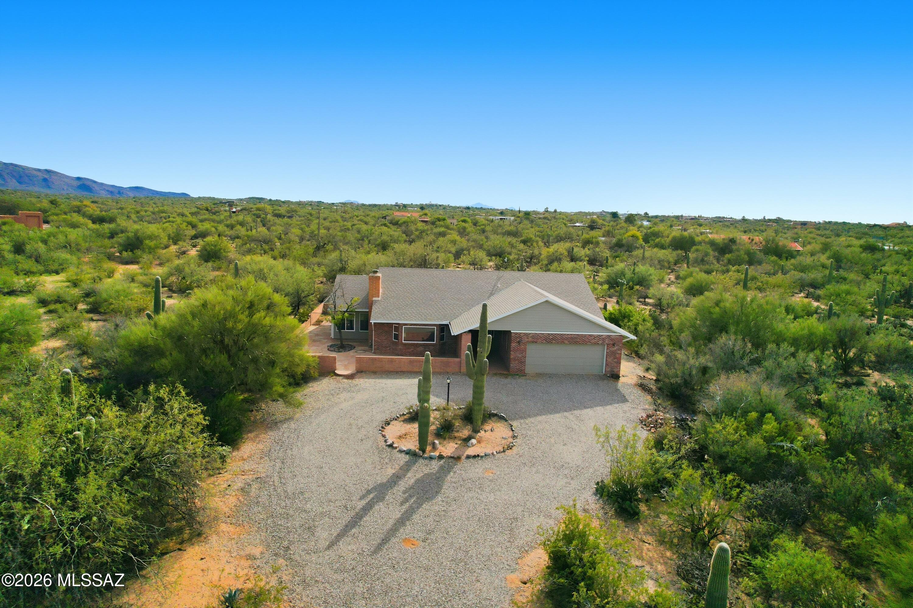 HORSE PROPERTY, NO HOA, NO DEED RESTRICTIONS. Welcome to this East Side Beauty on 4.77 Acres with mountain views and privacy in this beautifully maintained home on a quiet East side trail. Walk in the entry to a spacious foyer opening to three family rooms one complete with a brick wood burning fireplace. Open floor plan features vaulted ceilings, spacious living areas , and abundant natural light with views from every window. Country kitchen with breakfast nook offers ample cabinetry and connects seamlessly to living spaces. Large 4.77 acre lot that is covered with Mesquite trees where many different birds visit from the nearby Saguaro National Monument during the morning coffee. Convenient to all the Eastside shopping, dining and outdoor recreation, Twin Hills is a special place to own.