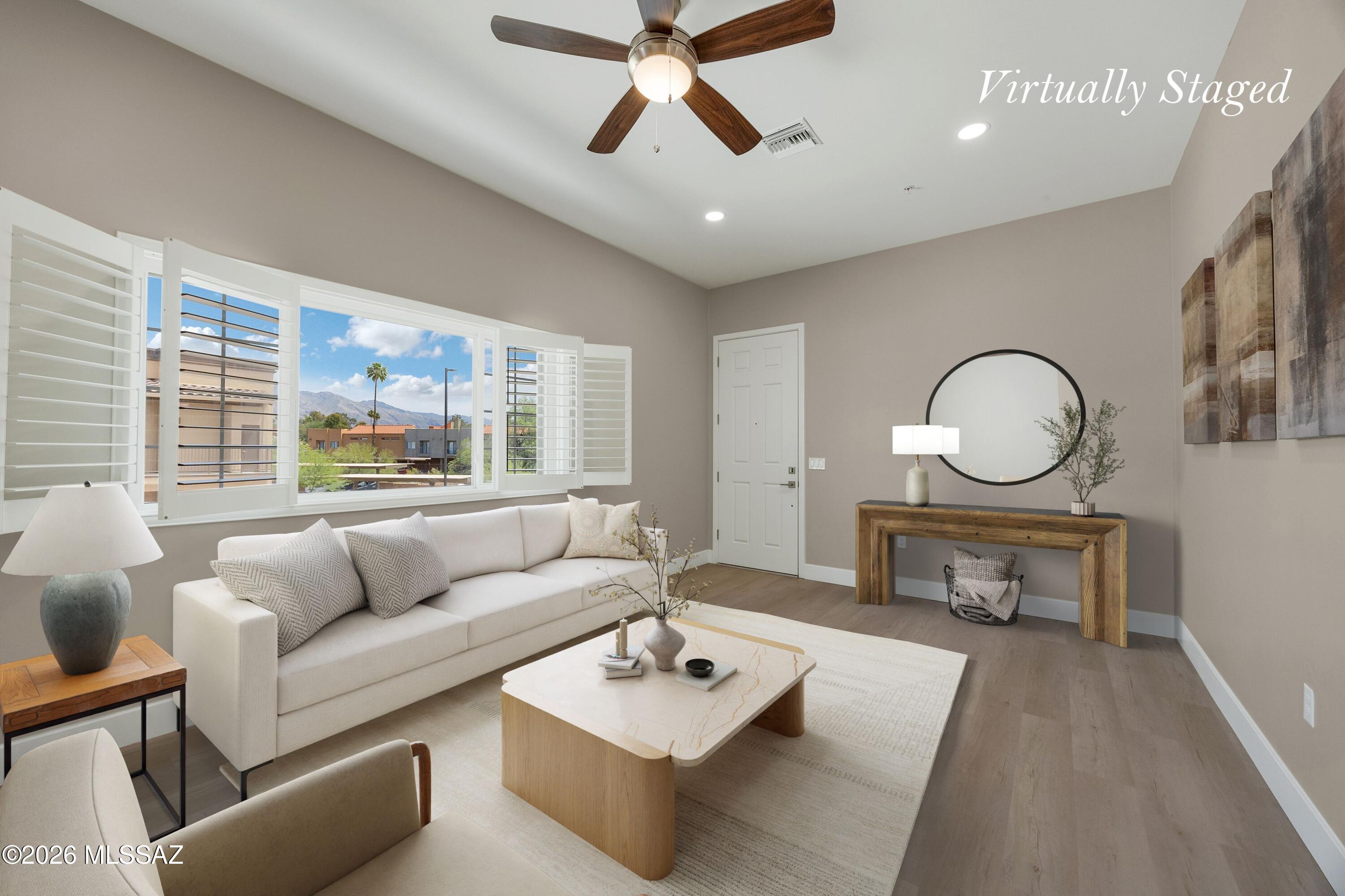 Private, immaculate and quiet, this upper-level corner condo is positioned further away from neighboring buildings. The north-facing great room captures soft natural light and hints of mountain views, with direct access to a relaxing balcony. The open-concept layout features a well-appointed kitchen, two spacious bedrooms, and two full bathrooms. Storage is abundant, including a large pantry and an oversized walk-in closet with built-in organization. Plantation shutters add a refined touch throughout. Built in late 2023. Enjoy effortless living with a community pool and spa just steps away. Ideally located in gated community near St. Philip's Plaza with dining, shopping and entertainment, the Loop and Riverwalk (with direct gated access), bike paths, Trader Joe's, the University of Arizona, and Banner Health. A designated covered carport space (#112) sits conveniently below the unit. HOA covers water, trash, and sewer. No rental restrictions.