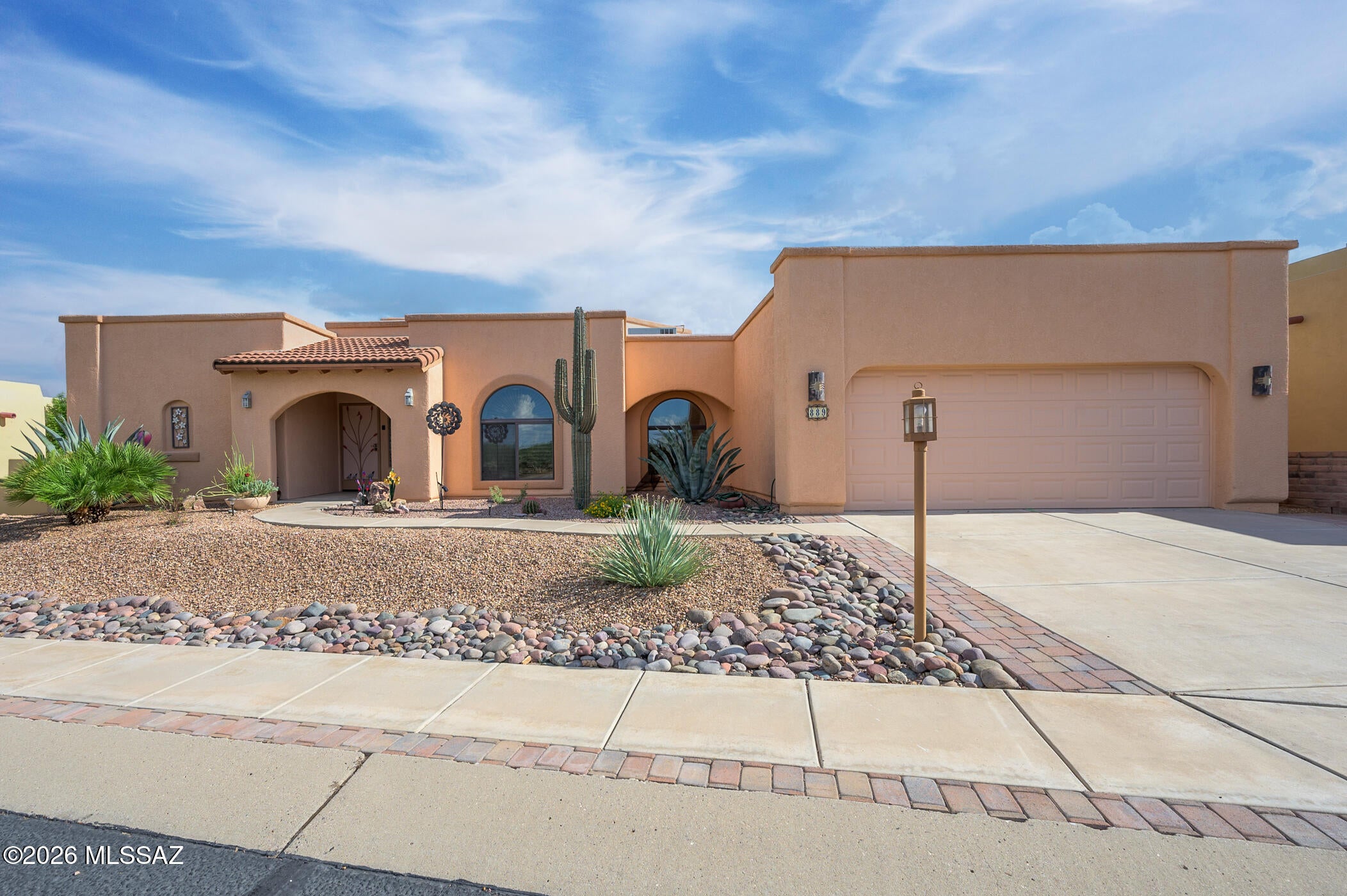 Experience the warmth and character of the Southwest in this custom Pierce-built home featuring distinctive Old Pueblo Mission-style architecture and quality 2x6 construction. Step inside to discover tile flooring throughout, hand-painted Southwest accents, and a dramatic great room featuring a latilla ceiling, clerestory windows, and a tall Kiva gas fireplace. Beautiful wood beams and columns frame the dining area and add to the home's authentic Southwestern appeal.

The spacious kitchen offers a center island, custom cabinetry with Talavera pulls, gas range, and newer slate French-door refrigerator. A desirable split-bedroom floor plan provides privacy for visiting family and friends. The spacious primary suite features a walk-in shower and countertops finished with Italian tile. The third bedroom, complete with a closet and grand double doors, is currently used as a den and offers flexible space for an office or formal dining room.

Enjoy Southern Arizona living year-round from the south-facing screened porch with views of the Santa Rita Mountains, colorful sunrises and sunsets, and dramatic summer monsoons.

Additional features include Tesla leased solar, a newer water heater, an extended garage with extra storage.
