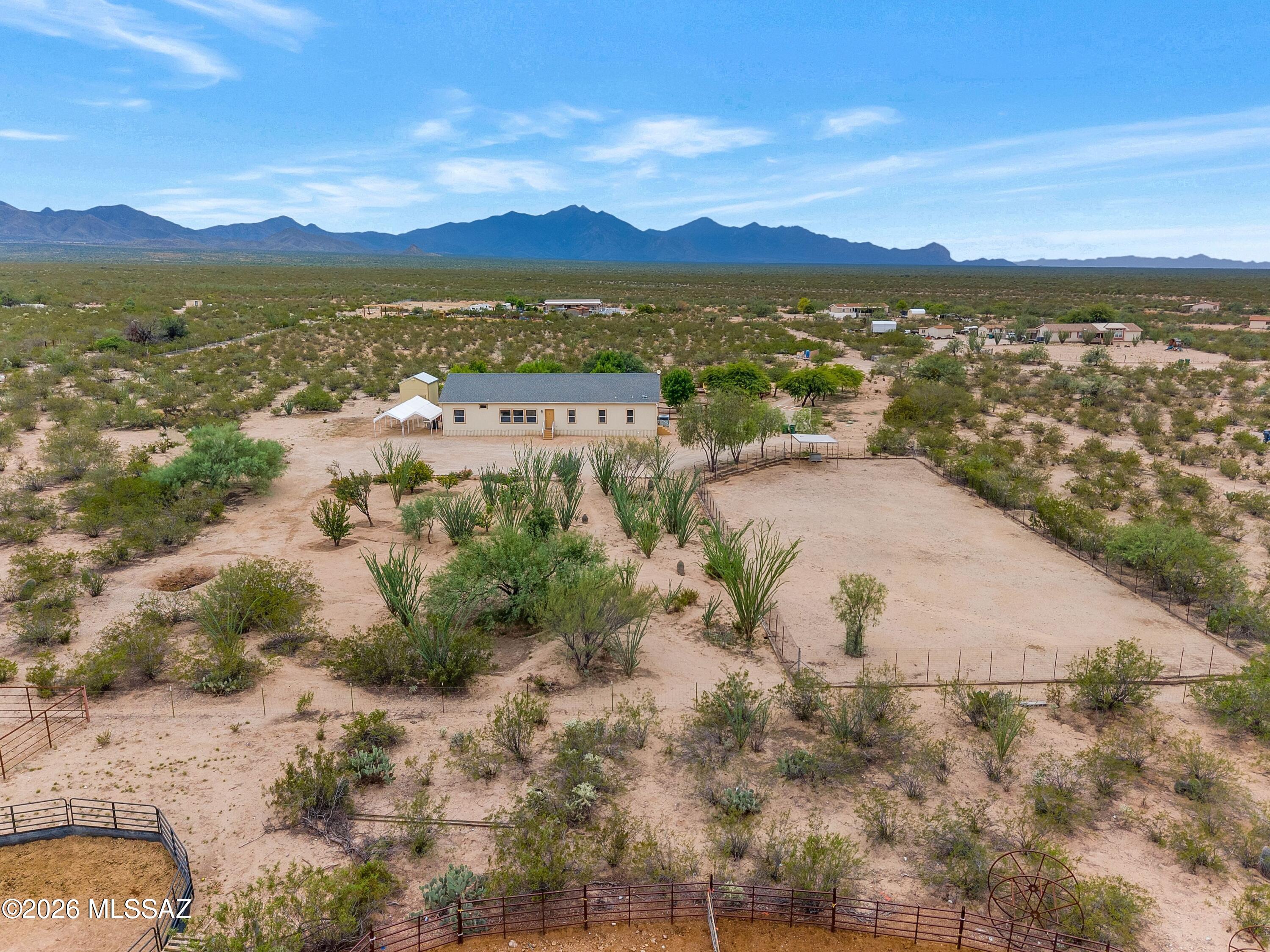 Wide open spaces & majestic Santa Rita Mountain views! Set on 4.4 acres, this 4 BR / 2 BA home offers the freedom to spread out, bring your horses & livestock, park the RV & enjoy a quieter way of life. Start your mornings with mountain views and unwind in the evenings on the expansive covered porch beneath the Arizona sky. Inside, 9-ft ceilings, spacious living areas & generous granite kitchen create a comfortable place to gather. Quality construction includes 2x6 exterior walls, engineered Anchorpanel® permanent foundation, 400 amp service, 12-gauge copper wiring & 1,500 gallon septic. Two RV sewer connections, whole house water filtration, RO system & covered parking for 3 vehicles add convenience. Space, serenity & room to roam! USDA financing available.  Enjoy mature landscaping.