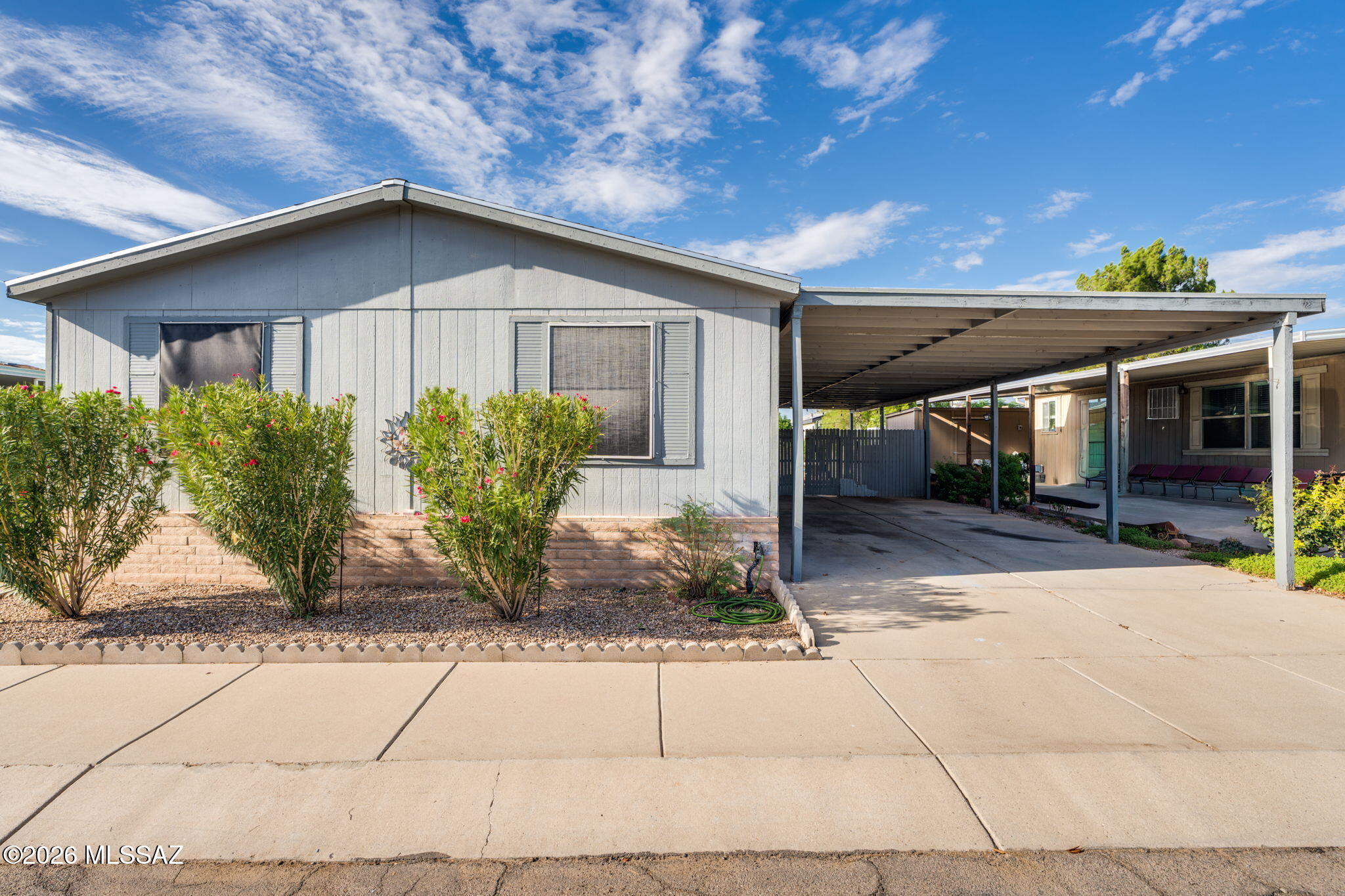 Welcome to this well-maintained 4-bedroom, 2-bath manufactured home in a gated Central Tucson community with a low HOA! Featuring an inviting open floor plan, great room, dining area and breakfast nook, creating a comfortable layout for everyday living and entertaining. Laminate and tile flooring run throughout the home--no carpet! Enjoy plenty of outdoor living space with a large, covered patio, along with a 4-car covered carport providing ample parking and versatility. A block perimeter wall adds privacy and definition to the property. Recent major upgrades provide added peace of mind, including a new roof in 2022, HVAC system in 2023, 200-amp electrical service in 2023, and water heater in 2024. Conveniently located in Central Tucson, this home combines space, functionality, privacy, and value in a gated community with a low HOA.