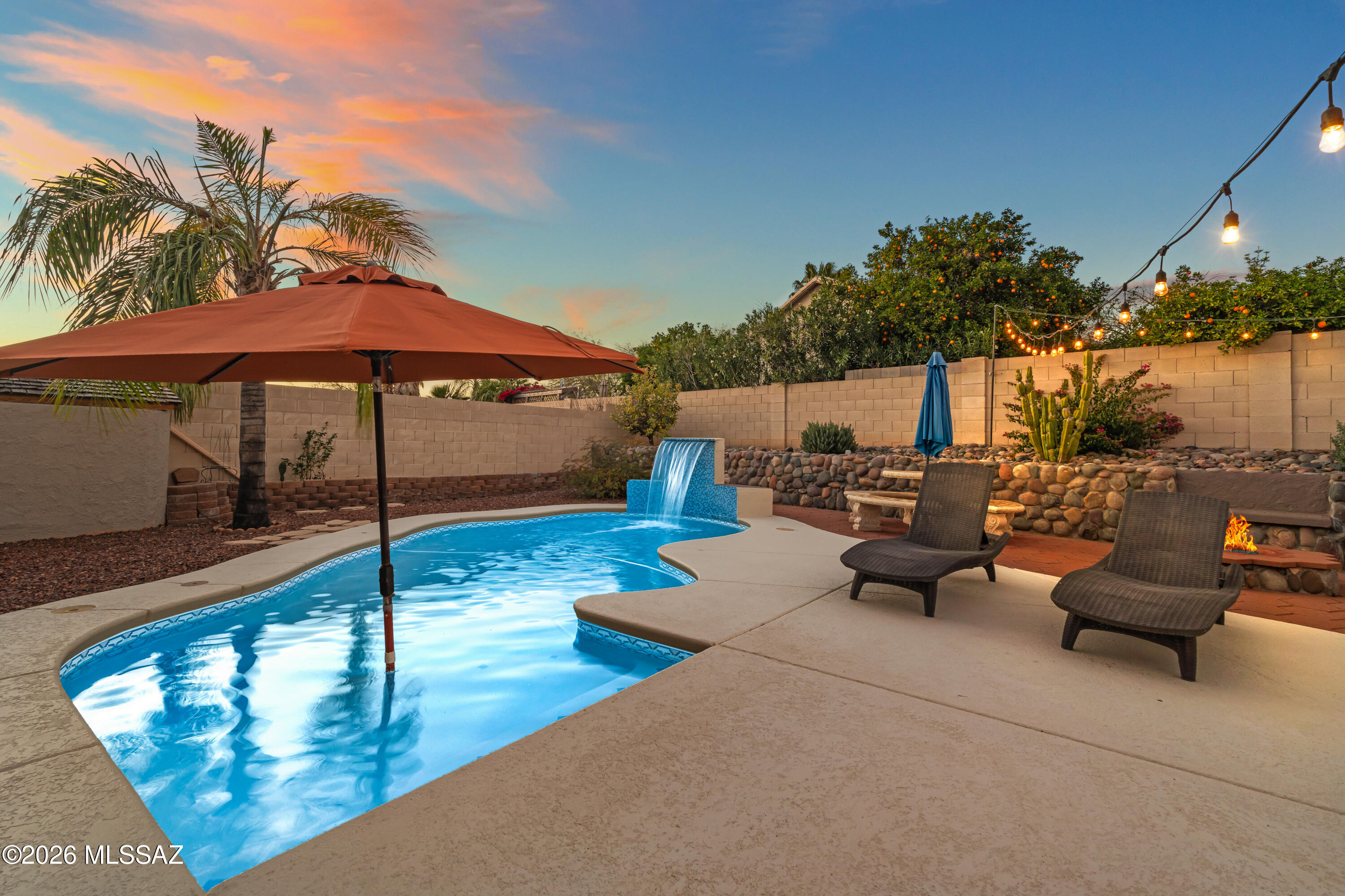 Welcome to 11032 N Divot Dr in Oro Valley, where thoughtful upgrades meet resort-style outdoor living. The north-facing backyard offers afternoon shade and features a saltwater pool, separate hot tub under a gazebo, gas fire pit, built-in concrete seating, and BBQ area with refrigerator--perfect for entertaining. Mature apple, blood orange, and lemon trees add charm. Inside, enjoy a gas fireplace, 5.1 surround sound, Miele dishwasher, and smart LG appliances. Energy efficiency includes owner-owned solar and an updated Trane HVAC system. The insulated garage features AZ Cabinet storage, workshop space, attic access, and a 50-amp EV charger. Located in Catalina at Canada Hills, offering 36 holes of golf, scenic mountain views, and close proximity to shopping and dining.