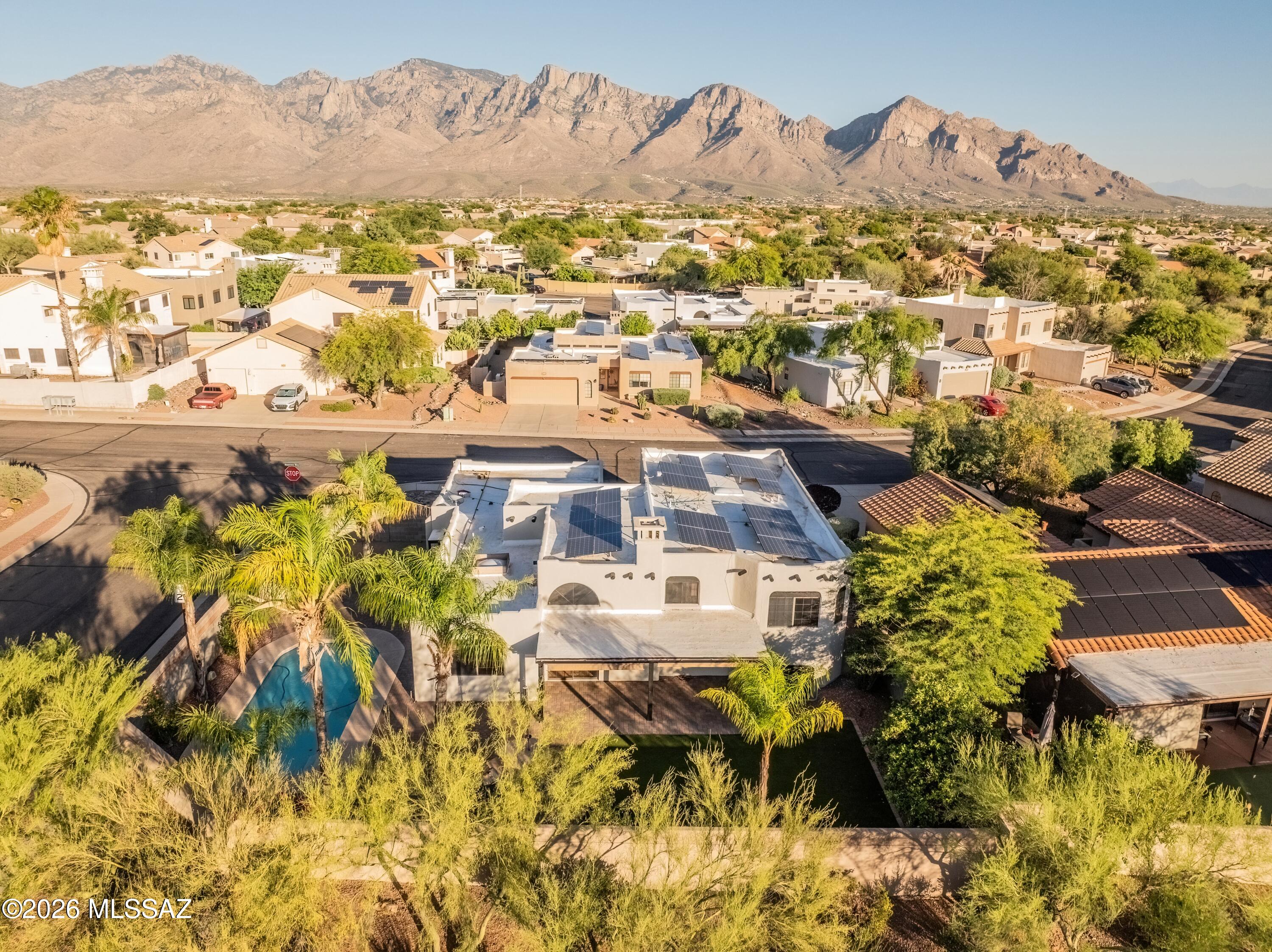 Mountain Views, Resort-Style Pool & Exceptional Oro Valley Living. Perfectly positioned on a premium oversized corner lot in the heart of Oro Valley, this beautifully updated tri-level home offers the ideal blend of space, comfort, and breathtaking Pusch Ridge mountain views. With 5 bedrooms, 3 bathrooms, multiple living areas, and a backyard designed for entertainment, this home delivers the Arizona lifestyle you've been searching for. From the moment you arrive, you'll appreciate the fresh updates, including new interior and exterior paint and a new epoxy-coated garage floor. Inside, abundant picture windows fill the home with natural light, while classic tile flooring and inviting living spaces create a warm and welcoming atmosphere. The spacious kitchen is designed for both everyday living and entertaining, featuring granite countertops, abundant cabinetry, and multiple dining areas. The adjacent family room is anchored by a charming wood-burning fireplace, creating the perfect setting for relaxing evenings and memorable gatherings. The versatile tri-level floor plan offers endless possibilities. The lower level includes two bedrooms and a full bath, making it ideal for guests, multi-generational living, a game room, home theater, fitness space, or private office setup. Upstairs, you'll find two additional guest bedrooms along with a generously sized primary suite featuring a walk-in closet and relaxing garden tub. Move outside and discover your own private oasis. The resort-inspired backyard showcases a sparkling pool, built-in BBQ, artificial turf, and multiple areas for entertaining or unwinding, all framed by stunning mountain vistas. Whether hosting friends or enjoying a quiet Arizona sunset, this outdoor space is truly unforgettable. Additional value comes from paid leased solar, helping offset energy costs while enhancing efficiency. Offering incredible flexibility, spectacular views, and one of Oro Valley's most desirable locations, this home won't disappoint.