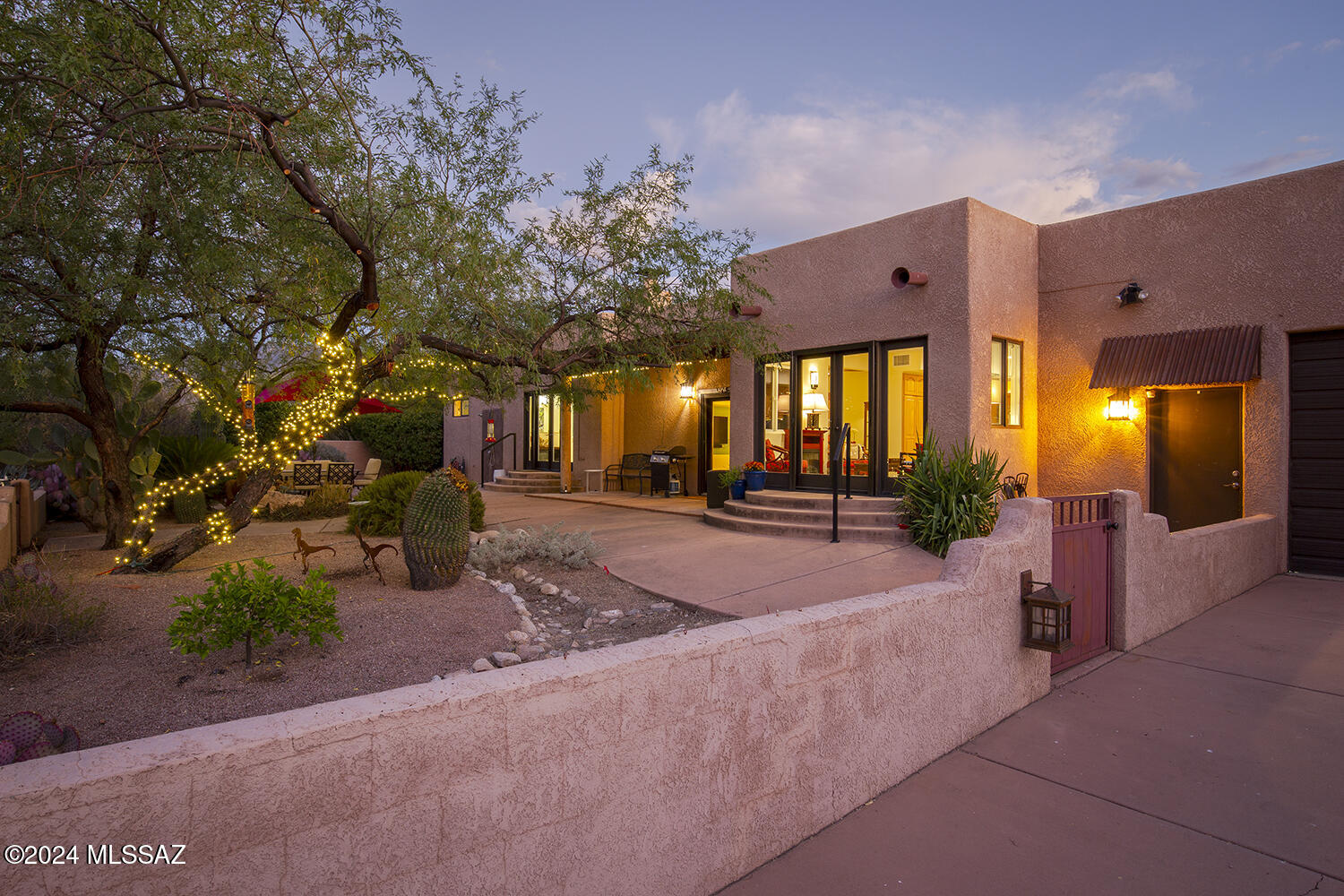 Panoramic views of the Catalina and Rincon Mountains. Stand-alone guest apartment  w separate entry. Exceptional Privacy in a secure setting. Fully enclosed, pack rat-proof RV barn featuring full hookups. Main house has 7 Large skylights. Elegant Durable travertine-look porcelain tile throughout. Whole-House Water Softener. Gated property. *Extensive Remodel 2020-2022 *Luxurious Main Suite: Dedicated office, dual vanity, and a mosaic-accent walk-in shower. Jetted tub with dual art glass vessel sinks. Elevated toilet/bidet and grab bars for added convenience. Opens onto courtyard with outdoor shower. *Bright, Functional Kitchen: Black quartz countertops and light wood cabinets. GE Profile WiFi-enabled Induction Range (2022) and Whirlpool dishwasher (2020). Spacious wall pantry and Spacious wall pantry and pull-out shelves. Under-cabinet tape lights.

Inviting Living Spaces: Cozy den or casual dining space with panoramic views. 2-step-down living room featuring a viga ceiling, beehive fireplace, and illuminated display shelves. Formal dining room with bookshelf-lined walls. Designer LED lighting (2021) throughout.

Outdoor Enhancements:
Computer-controlled irrigation system (2021), including orchard watering.
Front and back covered porches with viga ceilings and two walled courtyards with lush, mature landscaping.

Ample Storage & Workspace:
Over-height garage accommodating four cars or a hobbyist's workspace, with four skylights.

Enclosed 14' X 25' RV and equipment storage barn with 110V, 30-amp electricity, city water, and sanitary dump station.

Prime Location: Minutes from Northwest Medical Center, Saguaro National Park East, shopping, and recreational trails. Quick access to vibrant downtown Tucson.

Worry-Free Living: Large security gate and low-maintenance features for peace of mind during extended absences.