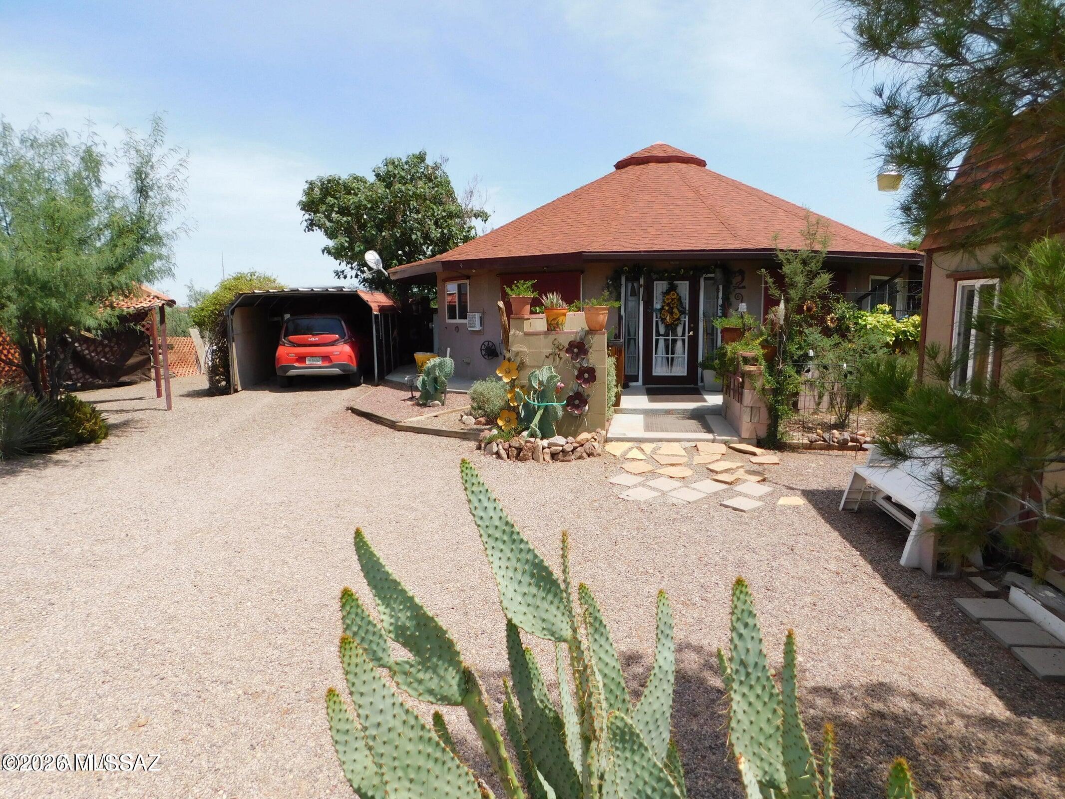 Shows like a model home worthy of magazine covers due to the current seller's attention to detail. This amazing retreat has 5 total tax codes and is on 2.28 acres. There is a shared well which is tested weekly by the water management company. A 2 bedroom - 2 bath plus Arizona room offers Zen-like features and curves. The aerodynamic properties of a circular home make the houses more resistant to harsh weather. The floor plan and design of this unique beauty invite positive spirituality and creativity. The seller has designed some of the most inviting and beautiful desert life gardens in the area. The circular Drive is one parking & entry area, but there is also an older entry off of Pueblo Dr. & one behind the home off of the extra ... ...North lots of this property giving THREE
separate possibilities of parking-entry & exits plus bringing in feed or adding stables, barn, arena, Or possibly Guest Home or office. Check with zoning.

The AMAZING ZEN Arizona Room is approximately 240 sq. feet and can be enclosed to make it another bedroom - office or whatever a buyer might need. Currently heated and cooled with wall units when needed.

There are 2 fantastic sheds already on the property as well as a designer hen house. One shed on the South side of the home has an attic.

This is an ENERGY EFFICIENT GREEN HOME***
The bathroom sinks and showers allow gray water to benefit the gardens, and there are also barrel water catchers available for the new owner to attach to the roof to collect rainwater.
The seller currently has 2 amazing portable AC units plus two window units that stay with the home. Plus ditech shades across the front of the house block 90% of UV rays making electric bills low - $80-$135 a month depending on the season.

The Master Bathroom has a stackable washer and dryer hook up and the hook up for the toilet is there just needs a toilet as this room was being used for laundry only but the plumbing is all available and used to have a toilet. There is space on the Arizona Room Patio to make a laundry room - The Master bathroom has a Shower and sink and wash/dryer hook up.

Fabulous mature tress and desert vegetation surround the home and private patios. A Large Tombstone Rose shades the small backyard, as well as mature grape vines.

The tax codes are : 406-24-540E Home on 0.58 acres - 406-24-540 C is 0.37 Acres/ 406-24-536 is 0.37 Acres /406-24-531 is 0.59 Acres and 406-24-532 is 0.37 Acres = Total 2.28 Acres with the home.