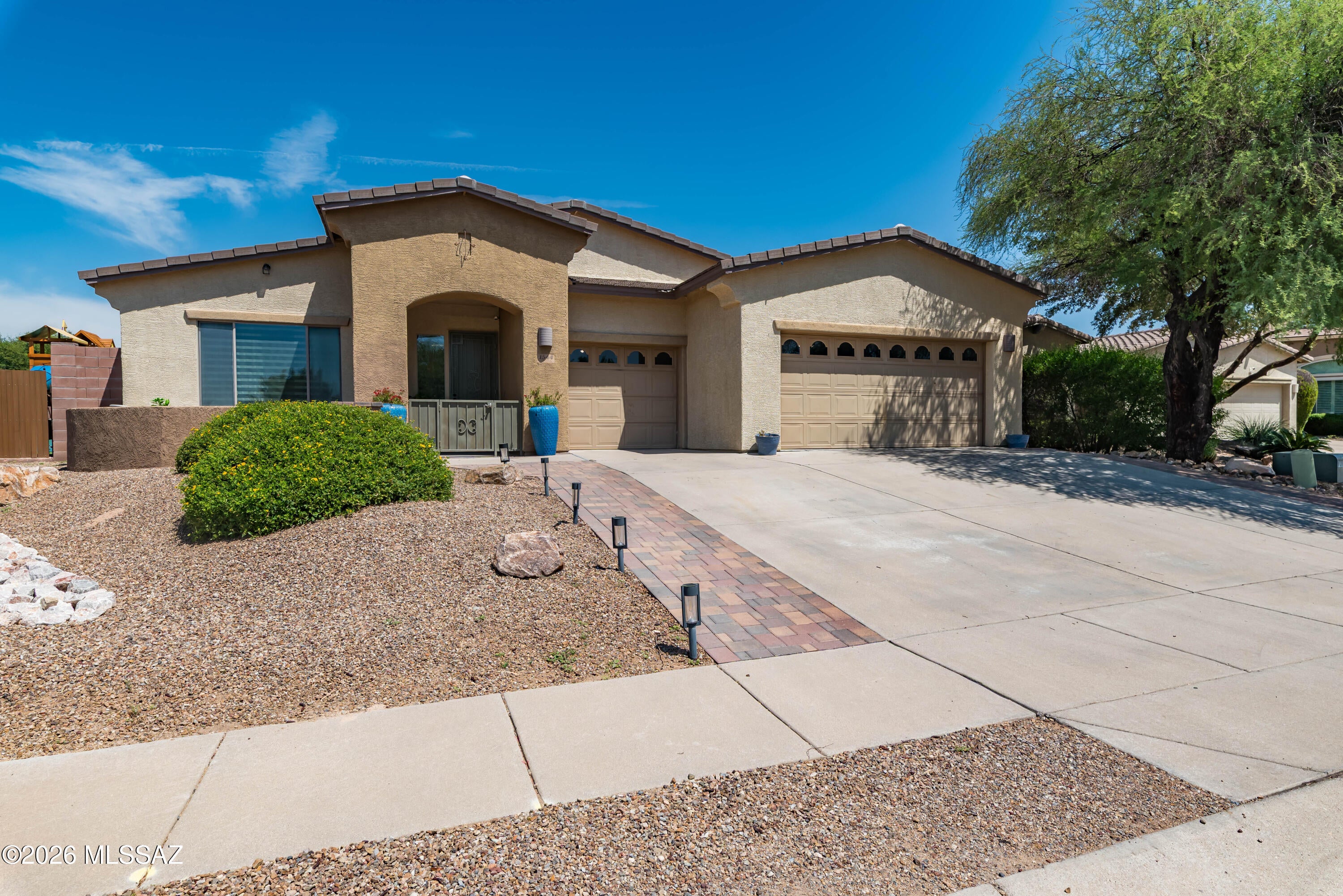 Welcome to this exceptional Oro Valley home situated on a quarter-acre, corner lot, in a quiet cul-de-sac. Spanning 2,780 sq. ft., the high ceilings frame it's comfortable, flowing, living spaces. This split floor plan features four bedrooms which include three ample secondary bedrooms. The interior highlights sleek quartz countertops in both the kitchen and the updated bathrooms. The primary bathroom will impress with its large tandem shower.  Step outside into a private backyard oasis built for entertaining, complete with a heated pool and spa; a covered patio, and a custom ramada with an outdoor kitchen.  A gated front patio, and an extended 3-car garage with overhead storage top things off at this lovely home that offers superb proximity to Oro Valley dining, shopping, golf, and parks. The interior features include a large living room and family room with high ceilings; a chef's kitchen with quartz counter tops and an island with seating; newer stainless appliances, a double oven and a gas stovetop; numerous cabinets and built-in buffets; a gas fireplace; larger bedrooms; updated bathrooms with quartz countertops and tiled showers; one Jack-and-Jill bathroom and one bathtub; a laundry room. The exterior features an enclosed front patio; a long driveway leading into an extended 3-car garage with overhead storage and epoxy floors; a large side yard with astroturf and a jungle gym; a storage shed; a private backyard with a heated pool and spa; a ramada with ample seating and eating space and an outdoor kitchen.