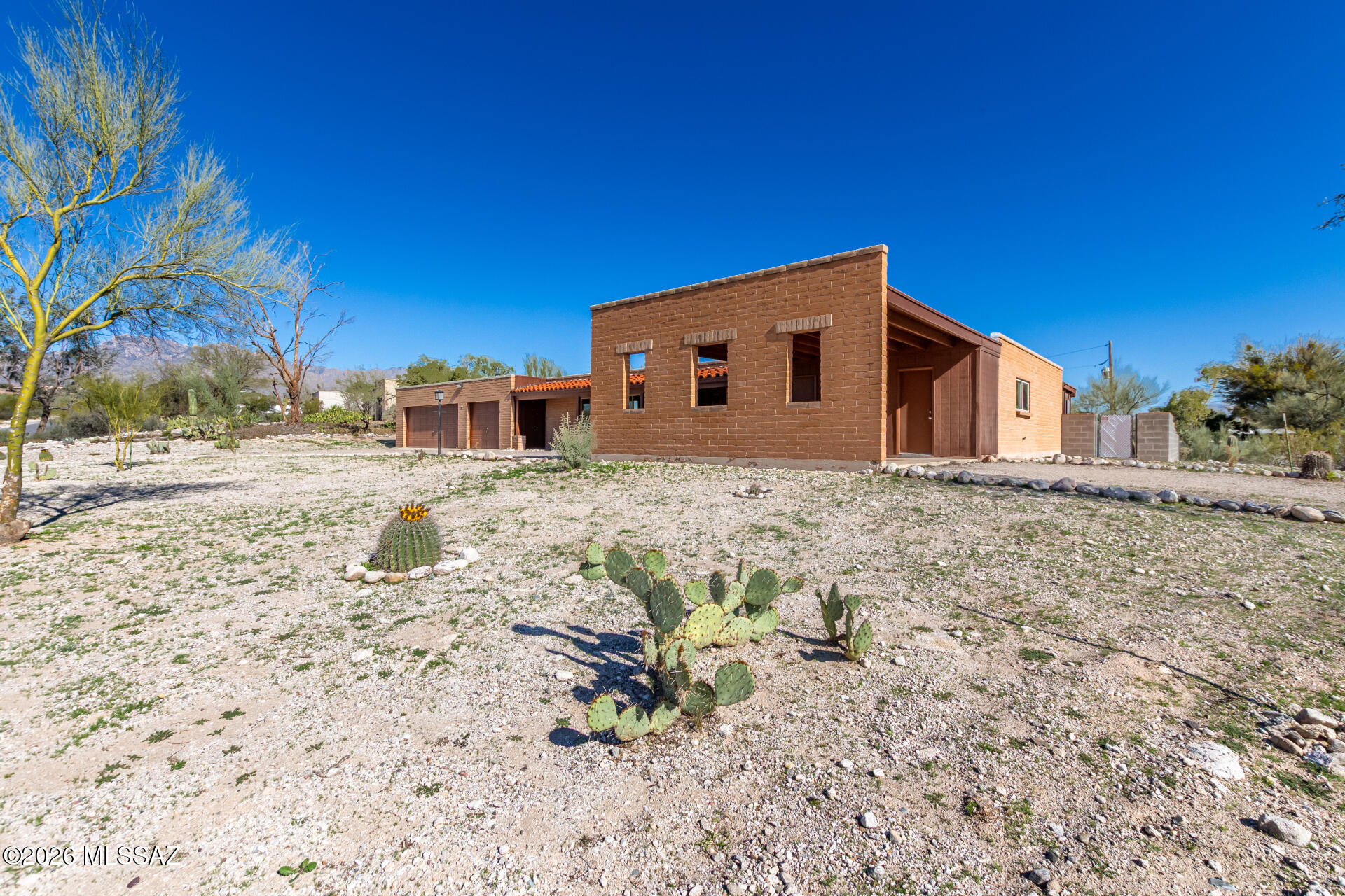 Beautifully updated 3-bedroom, 2-bath home with 1,917 sq ft of living space, featuring a 3-car garage/workshop and a 1-car carport. Situated on a spacious corner lot, this property offers  amazing mountain views. Inside, you'll find two fireplaces with quartz and wood mantels. One in the living room and one in the dining/kitchen area. The fully renovated kitchen includes brand-new GE electric stove, dishwasher, quartz countertops, new cabinets and lighting over the island. The bathrooms are updated with stylish tile surrounds. The entire home has been freshly painted and finished with all-new tile flooring throughout. The mudroom features a quartz top for added functionality. Additional living spaces include an Arizona room off the main bedroom