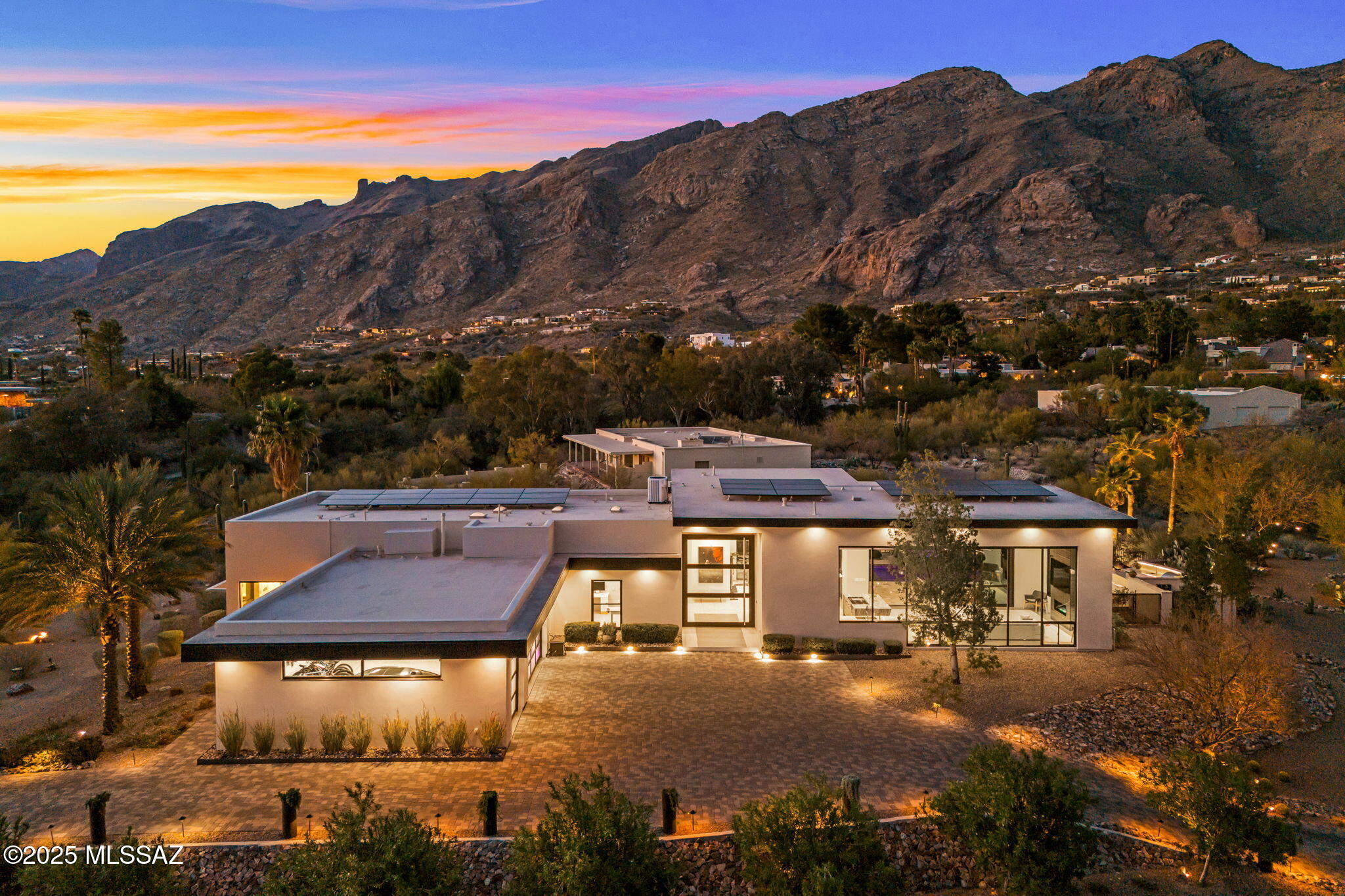 Experience the perfect blend of modern luxury and seamless indoor-outdoor living in this stunning TF Robertson-designed home, situated on 1.17 acres within the prestigious, 24-hour guard-gated Skyline Country Club Estates. Designed to impress, this 3,228 sq. ft. contemporary masterpiece offers four en-suite bedrooms, each featuring tray ceilings and custom lighting.

From the moment guests arrive, they'll be captivated by the grand 12 ft-high, 9 ft-wide front door, offering a breathtaking view that extends through to the majestic Catalina Mountains beyond.

Exceptional Design for Entertaining - the great room is an entertainer's dream, boasting soaring ceilings and a 12-ft multi-slide glass door that opens to an expansive patio. Here, you'll find a fire table, outdoor kitchen, and a heated pool and spa (built in 2023) with a self-cleaning system, all set against a panoramic Catalina mountain backdrop. A minimalist fence encloses the patio, ensuring unobstructed views while maintaining privacy.

Serene Owner's Retreat - wake up to stunning mountain views from the spacious primary suite, which features a walk-in closet with built-ins and direct access to the patio for effortless indoor-outdoor relaxation.

Sustainable Luxury & Smart Features - equipped with a 12.75 kW Tesla Solar System and three Powerwall battery backups (40 kW total), this home embraces energy efficiency. The oversized three-car garage includes a Tesla charger, while a whole-house water filtration system ensures optimal water quality. The smart home system connects indoor/outdoor accent lighting, motorized shades, and pool/spa features.

Resort-Style Community Amenities - Skyline Country Club Estates offers exclusive access to golf, lighted tennis and pickleball courts, a swimming pool, spa, and a state-of-the-art fitness center (membership required for certain amenities, inquire for more details). 

Don't miss the opportunity to own this exceptional modern home with unparalleled views and luxury living.