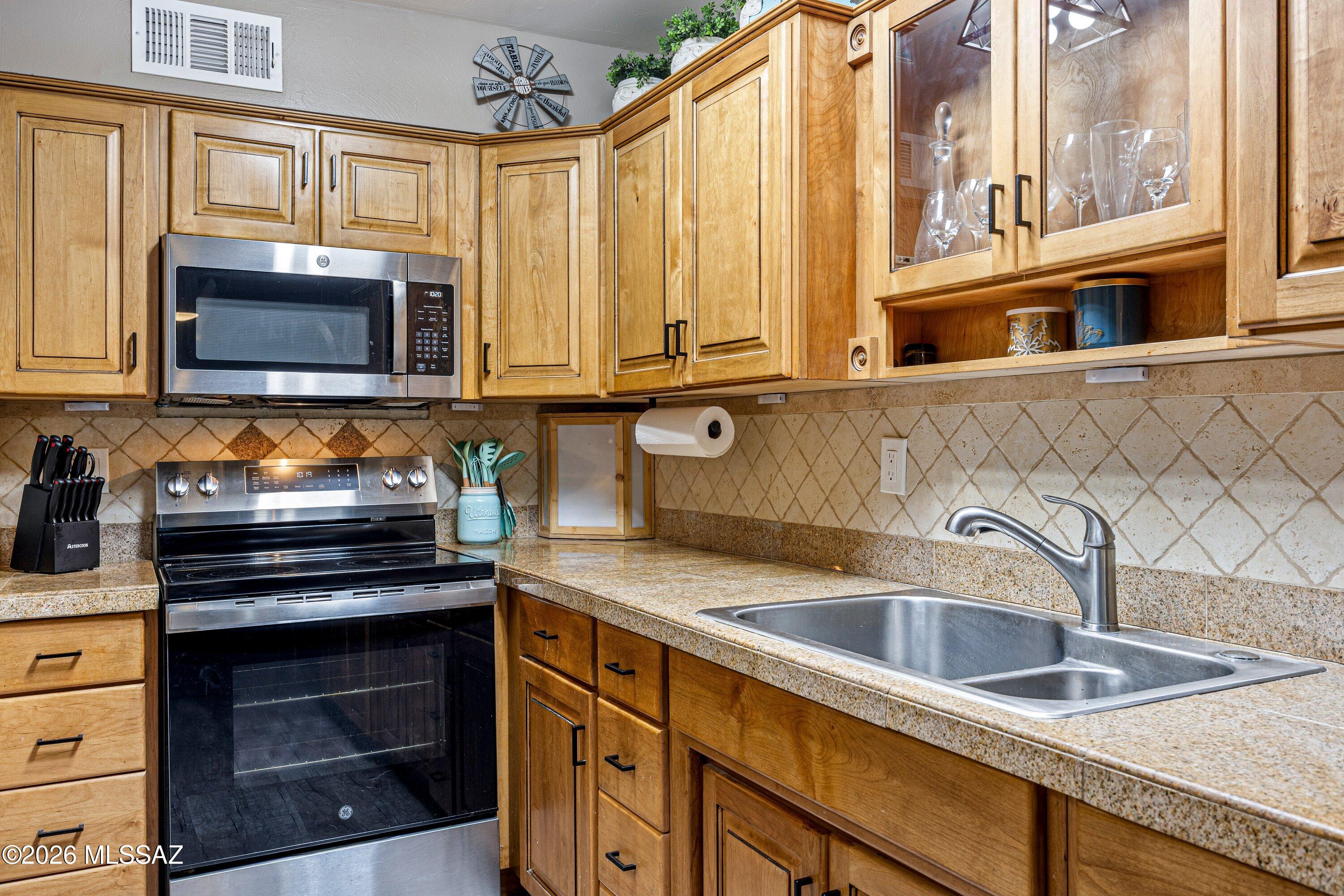 Beautifully updated 2-bedroom townhome with SPACIOUS DEN and 1,065 sq ft of comfortable living space. The kitchen showcases custom solid wood cabinetry, granite countertops, travertine backsplash, and new stainless-steel appliances. Bathrooms are updated with granite countertops and new light fixtures. Major improvements include a new roof, new HVAC and heater, fresh interior and exterior paint, and new ceiling fans and lighting throughout. Enjoy a spacious backyard that extends beyond the chain-link fence, offering additional outdoor space and flexibility. A charming home with thoughtful upgrades and great functionality throughout!