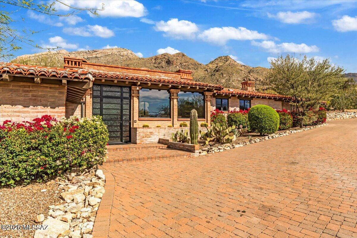 A rare opportunity to own a stunning piece of Tucson architectural history. Designed & built in 1963 by renowned Tucson architect Lewis Hall, this authentic burnt adobe residence embodies Hall's commitment to desert-sensitive design and his connection to the legacy of Josias Joesler. Hall masterfully blended Old World craftsmanship with Sonoran Desert materials -- thick masonry walls, hand-finished details, deep overhangs, and a seamless relationship between structure and landscape. Set on a private 1-acre lot within landmark Skyline Country Club, this 3,978 sq ft residence captures breathtaking Catalina Mountain views through expansive picture windows while embracing mature desert vegetation and natural terrain. Thoughtfully designed for both intimate living and gracious entertaining, the home features 4 bedrooms and 3.5 bathrooms, a bonus/opt 4th bedroom, two striking fireplaces, upscale kitchen design, gorgeous wood floors throughout, hand-hewn wood beams and classic burnt adobe construction. Multiple patios create effortless indoor/outdoor living, spiral staircase leads to a roof deck -- the perfect vantage point to take in dazzling sunsets. An expansive circular paver drive and 2-car garage complete the estate setting. The combination of architectural provenance, authentic materials, generous lot size, and iconic foothills location makes this a truly exceptional offering -- ideal for buyers who value timeless Southwest design, historic influence, very high-quality finishes and the enduring beauty of desert-adaptive architecture.