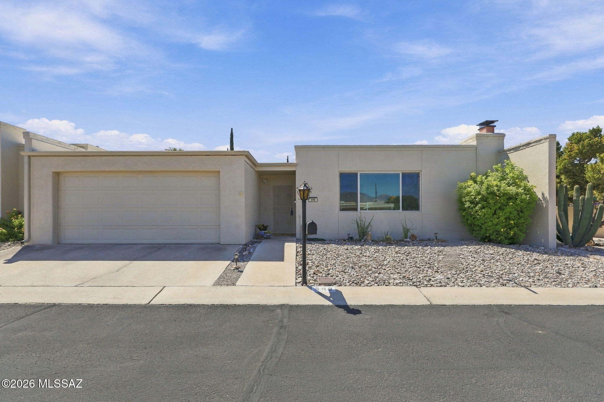 Mornings start with the Catalinas framed in the living room picture window and end at the fountain in a private walled courtyard, and there is room to enjoy both. At 1,736 square feet, this is the largest floor plan in El Dorado Townhomes: a true three bedroom where most units have two, opening to a big backyard with brick patio and permanent shade awning. Inside is real Tucson character, with saguaro rib accents, hand laid Saltillo tile, a kiva fireplace, and two Southwestern baths redone in copper, pine, and tile. Best part? This home has been meticulously maintained. The expensive work is behind you: pipes relined, HVAC replaced (warranty to 2032), newer electrical panel, water heater, seamless gutters, and GE stainless appliances. Low HOA covers the pool, clubhouse and front yard care. Light pours in through skylights in the kitchen and both baths, and every window is double pane with cellular shades, several set on hand laid Mexican tile ledges. Floors run about 70% Saltillo tile with decorative borders and 30% oak style laminate. The primary bath is fully tiled with a walk-in shower and safety bar; the second has a full tub. The kiva fireplace was serviced in 2025 with a new liner, cap, and spark arrestor, ready for your first cold night. A carved solid wood door opens to the garage, and the courtyard sits behind its own metal security door, where a windowed workshop with a lockable door handles everything a townhome usually has nowhere to put. The two car garage adds three tall built-in storage cabinets and overhead racks. Four drip zones keep the courtyard and backyard easy while the association tends the front. A video doorbell and motion sensor light cover the entry. Unpack, pour something cold, and go watch the sunset hit the mountains.