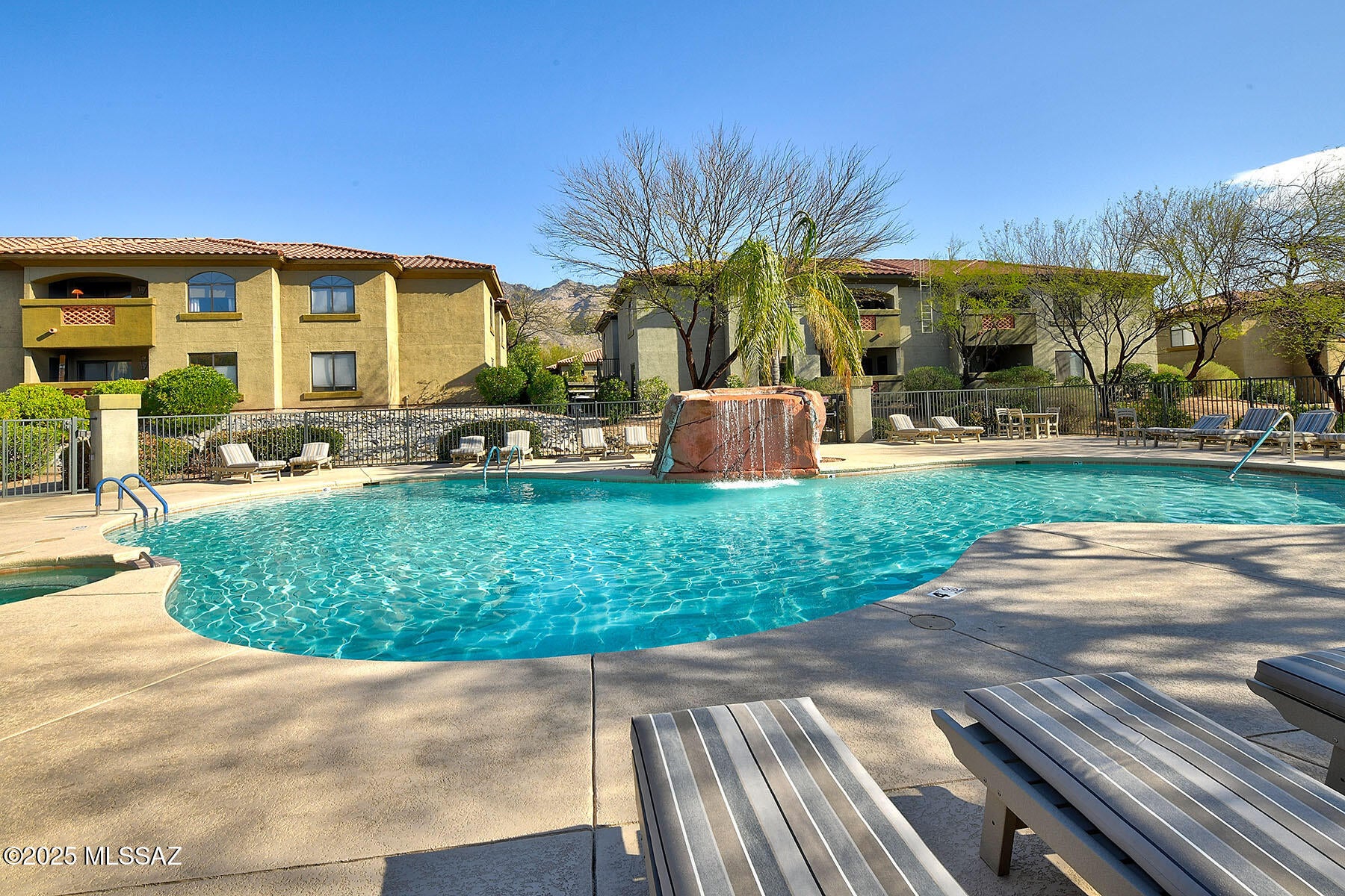 Fantastic premium corner ground floor 2 bedroom/2 bathroom condominium nestled in the resort like community of Veranda at Ventana. This light & bright home offers a dramatic rock wall backdrop which envelopes the rear of the home offering incredible privacy. No interior steps or steps leading to the front door. Enjoy the great room concept with spacious living and dining areas that open to the beautiful kitchen with gorgeous wood cabinets, granite countertops, stainless steel appliances, deep double bin sink with detachable spray handle & modern lighting. Primary bedroom suite features brand new carpeting, a large walk-in closet, walk-in shower and updated vanity, lighting & fixtures. Split bedroom floorplan with newer carpeting in bedroom two which is located adjacent to the second bathroom. Many upgrades including Springwell Whole House Water Filtration System, new Bradford White 50 gallon water heater, 7-year transferable HVAC service plan, 2" wood blinds, contemporary ceiling fans with remotes, new screens, fresh new paint - and more! Washer/dryer/refrigerator all convey. Furniture/furnishings available on a separate bill of sale. Veranda at Ventana offers a resort like setting featuring many amenities including fitness center, two pools, two spas, clubhouse, children's playground & BBQ ramadas. HOA covers roof, building exterior, garbage, exterior termite & pest control, streets, and more. Close to world class golf at Ventana Canyon, hiking/biking/swimming/picnicking at Sabino Canyon Recreation Center and great restaurants & shopping. Truly a spectacular property!