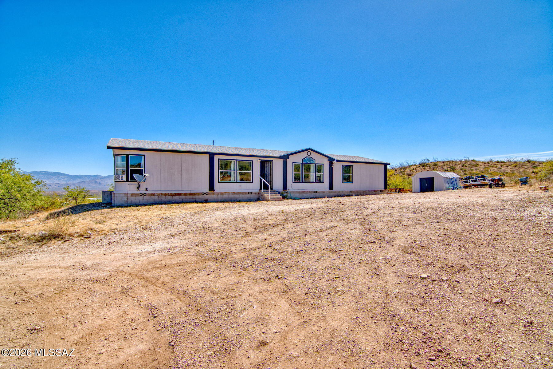 Escape to your own private retreat on 5.25 acres in scenic Vail, AZ! This spacious 4-bedroom, 2-bath manufactured home offers 2,240 sq ft of comfortable living with vaulted ceilings, ceiling fans, and a functional open layout. The kitchen features a gas range, dishwasher, microwave, and breakfast bar, perfect for everyday living. Enjoy a dedicated laundry room, den, and generous walk-in closets. Step outside to a deck with sweeping panoramic desert and sunset views from your private hillside lot. Horse property by zoning with RV parking available and no HOA holding you back. Propane, septic, and well water keep you wonderfully self-sufficient. Located in the highly regarded Vail School District. A rare opportunity to own wide-open Arizona land with room to roam!