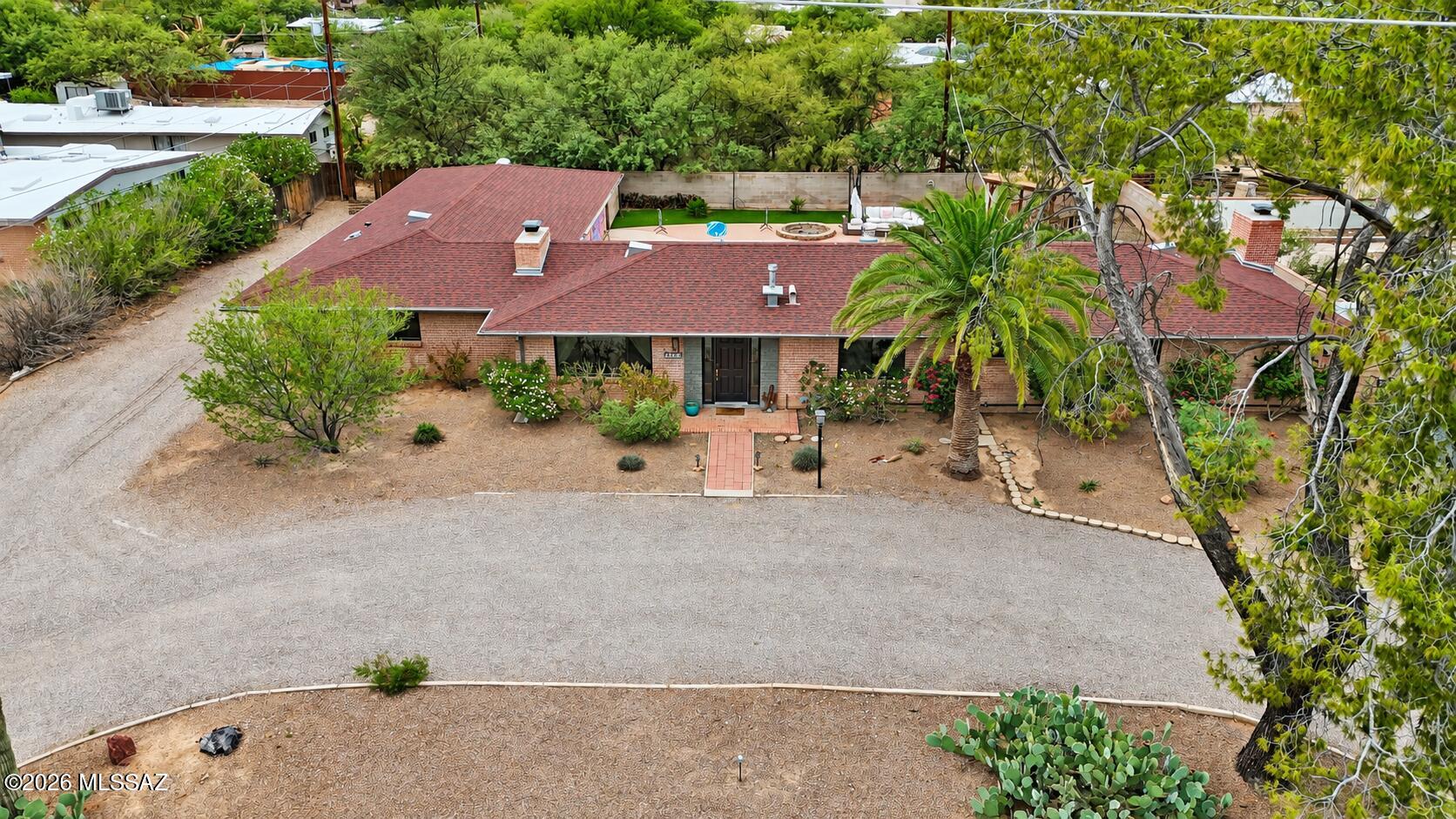 Set back from the road behind a large circular drive, this beautifully maintained single-story home offers privacy, mountain views, and an oversized lot with RV parking in the desirable San Carlos neighborhood of Central Tucson.

Inside, an open-concept kitchen, living, and dining area is anchored by terracotta-colored concrete floors, wood shutters, and alder wood doors, all set against a neutral palette. The kitchen features granite countertops, abundant cabinetry, and stainless steel appliances, while wood-burning fireplaces with wood mantels add warmth throughout. Smart-home features offer convenient control of the thermostat and front door, and a new AC (2025) adds peace of mind. The backyard is made for entertaining: a brick-walled retreat with an in-ground pool, professionally installed turf, a gazebo, a fire pit, and a custom mural by renowned street artist CYFI. The attached two-car garage includes a workshop and a new garage door (2024), with additional space alongside for RV parking. Located in the established San Carlos neighborhood, the home is just minutes from Tucson Medical Center (approx. 3 minutes) and Banner-University Medical Center (approx. 10 minutes), along with major employers, shopping, and dining. Single-story living, generous indoor and outdoor space, mountain views, and a central location make this home as convenient as it is inviting.