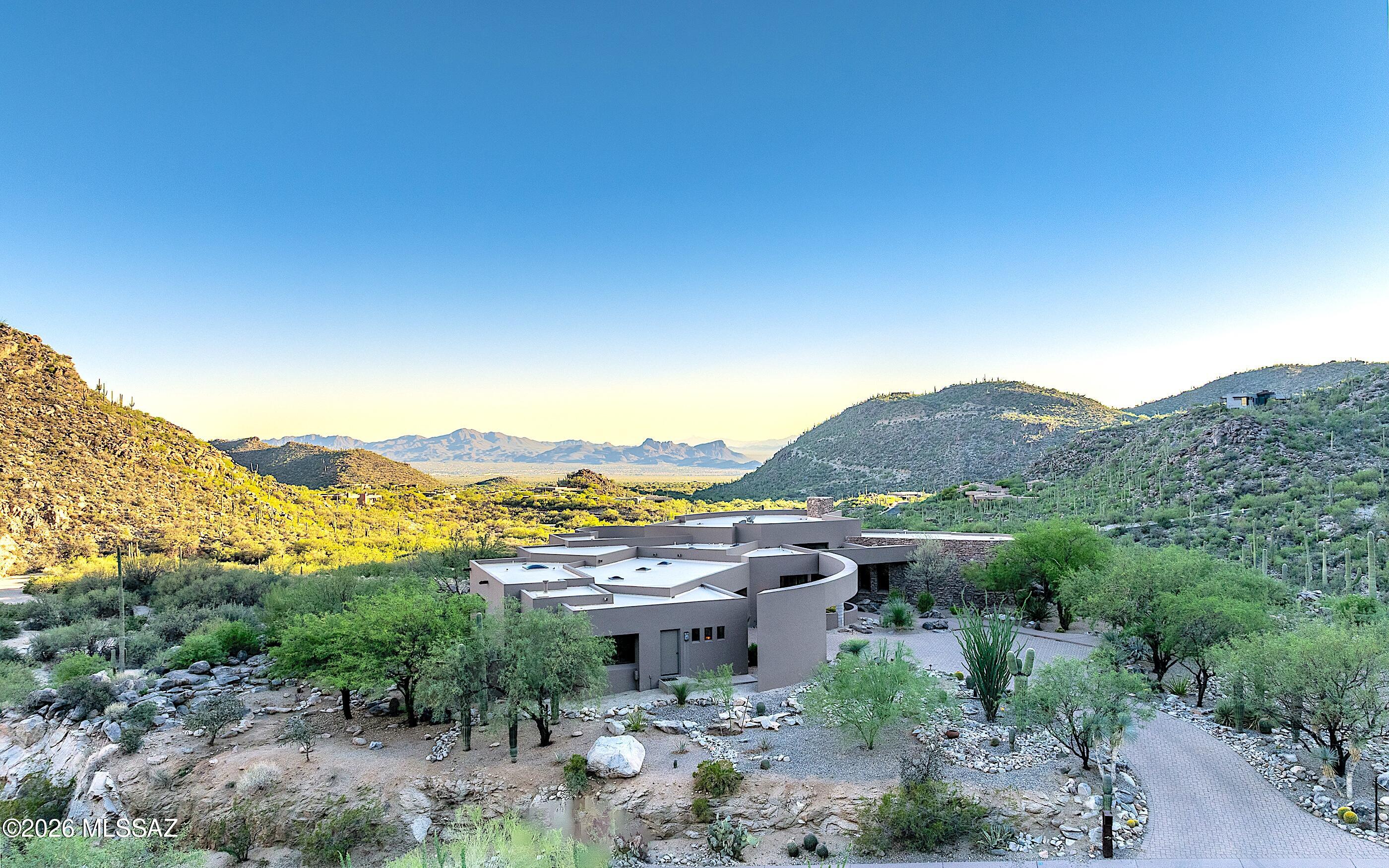 An exquisite custom Robinette Design masterpiece-solid construction w/finest of workmanship/finishes. Elevated corner lot hosts outstanding backyard living w/views to the SW - beautiful Marana city lights, endless desert & mountain views from all windows, late morning sunrises. Nestled perfectly into the rocks of the Tortolita Mountains-a private deck of relaxation & awesome views. Very well-maintained home: roof sealed/coated in May 2024, totally new irrigation landscape lines installed 2022. This residence promises to redefine your concept of comfortable luxurious living, offering an exquisite blend of luxury, elegance, sophistication & artistic architectural craftsmanship. Fabulous gourmet entertainers kitchen. Newly converted 'bonus' room to additional very large garage. Much storage!