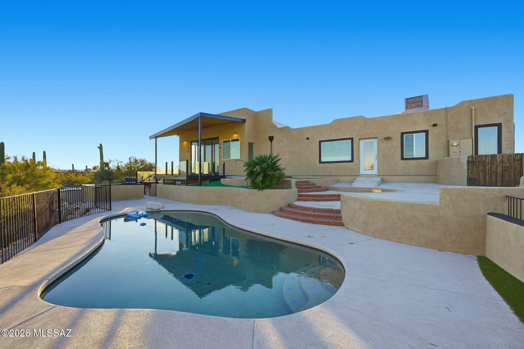 Perched on an elevated one acre lot in Hillcrest Estates, this stunning four bedroom four bathroom residence commands sweeping city and mountain views from every major room. Floor to ceiling windows in the family room frame a panorama of twinkling city lights and dramatic desert sunsets, creating a true showcase of Tucson living with effortless flow to the outdoor spaces for intimate evenings or grand entertaining.

The kitchen features granite counters, a large island, abundant cabinetry, and a picturesque bay window overlooking the backyard and mountain backdrop. A wet bar, high ceilings, and multiple living and dining areas elevate the home's sense of space and sophistication.

The primary suite is a retreat designed for royalty, offering room for a generous sitting area around the electric fireplace. The suite includes a walk in shower, refined finishes, and a walk in closet of remarkable size. The additional bedrooms are thoughtfully placed and generously sized, with two connected by a beautifully appointed Jack and Jill bathroom featuring a walk in shower.

Outdoor living shines with desert landscaping, multiple patios and decks, and a sparkling conventional pool equipped with a Katchakid safety system. The elevated setting delivers unobstructed views of the city, desert, and mountains, creating a breathtaking environment day and night.

Additional features include two fireplaces, zoned heating and cooling, epoxy and tile flooring, a two car garage with storage, and a corner cul de sac location offering the privacy and presence only a hillside lot can provide. This is a rare opportunity to own a true view property that blends modern comfort with timeless desert beauty.