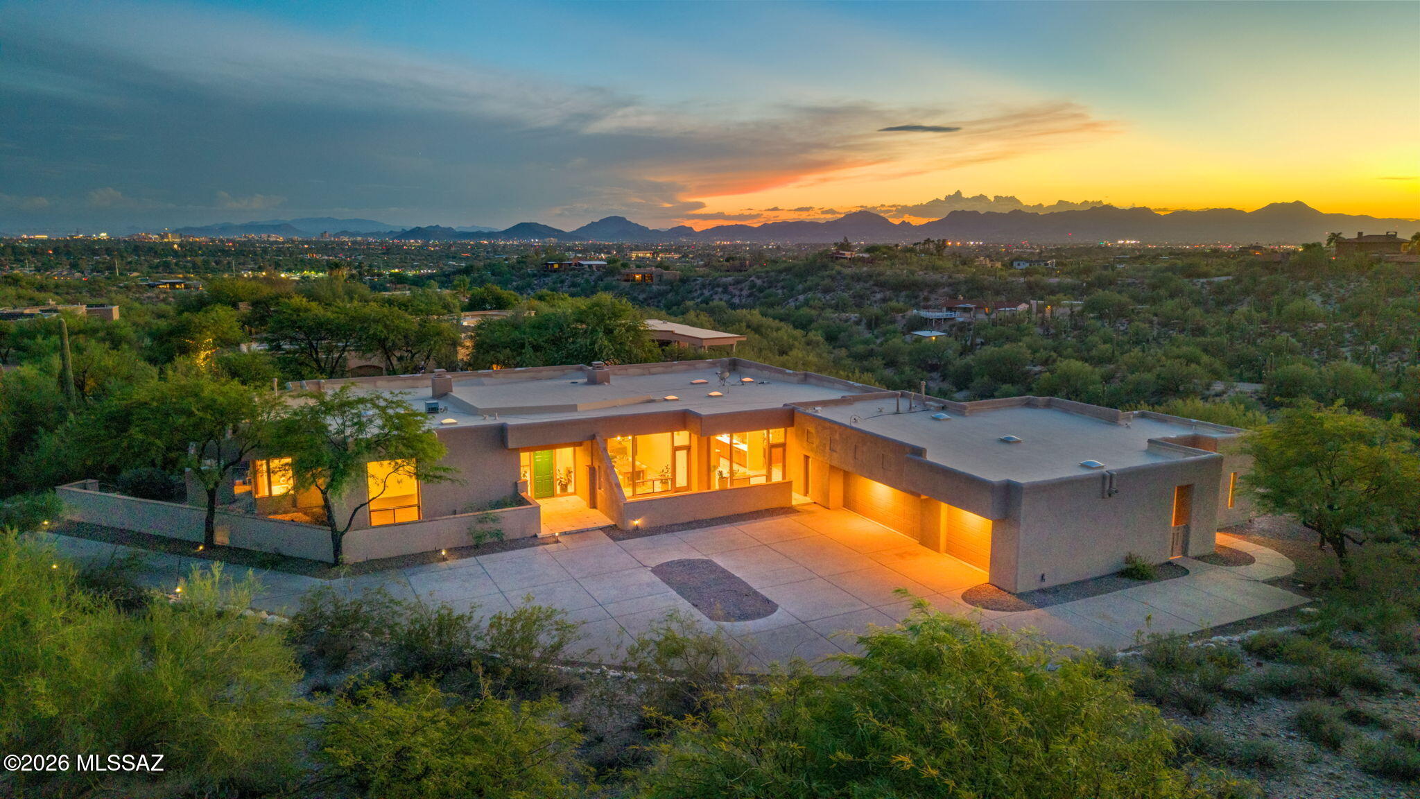 Exceptional single-level contemporary estate designed by Tyson-Murphy, perched atop a private 2-acre ridge-top lot in the prestigious, guard-gated Catalina Foothills 10 community. Tucked away on a quiet cul-de-sac, this 5,052 sq. ft. home features 5 bedrooms, 4 bathrooms, split floor plan, & includes a private attached guest house/casita w/independent exterior access. Upon entering, Floor-to-ceiling wood-trimmed windows bring the desert indoors throughout the home, w/Finger Rock framed from the dining room. Sunsets from the breakfast nook & west-facing rooms are spectacular, & evening city lights are visible from the casita, back bedroom & rear grounds. Architectural details abound, including exposed beams, art niches, a cozy double-sided fireplace shared by the living & family rooms, a 3 car garage with even more built-in storage.  The expansive primary suite serves as a luxury retreat, complete with a private fireplace, direct backyard pool access via glass French doors, dual walk-in closets, custom linen storage, separate dual vanities, tub, and a standalone shower.
At the heart of the home is a fully remodeled kitchen (2023 by Hartman Construction) featuring custom Rift white oak cabinetry, Taj Mahal Satin Quartzite countertops, Zia glazed-brick backsplash, and a massive center island. Designed for top-tier culinary experiences, it features premium stainless steel appliances--including a Wolf gas range with griddle, Bosch wall convection oven and microwave, dual KitchenAid dishwashers, Frigidaire Professional full-size refrigerator and freezer, warming drawer, dual sinks, and an RO system. Adjacent is a walk-in pantry, generous cabinet storage, and a wet bar complete with an ice maker and sink. An adjacent breakfast nook leads out to two separate patios.  The resort-style outdoor space features a deep covered patio, a heated lap pool, a spa, low-maintenance artificial turf, and a built-in gas grill--all fully enclosed within a private walled yard.  If you are seeking architectural distinction, modern updates, and wonderful desert vistas in an exclusive gated setting, this property is the one!