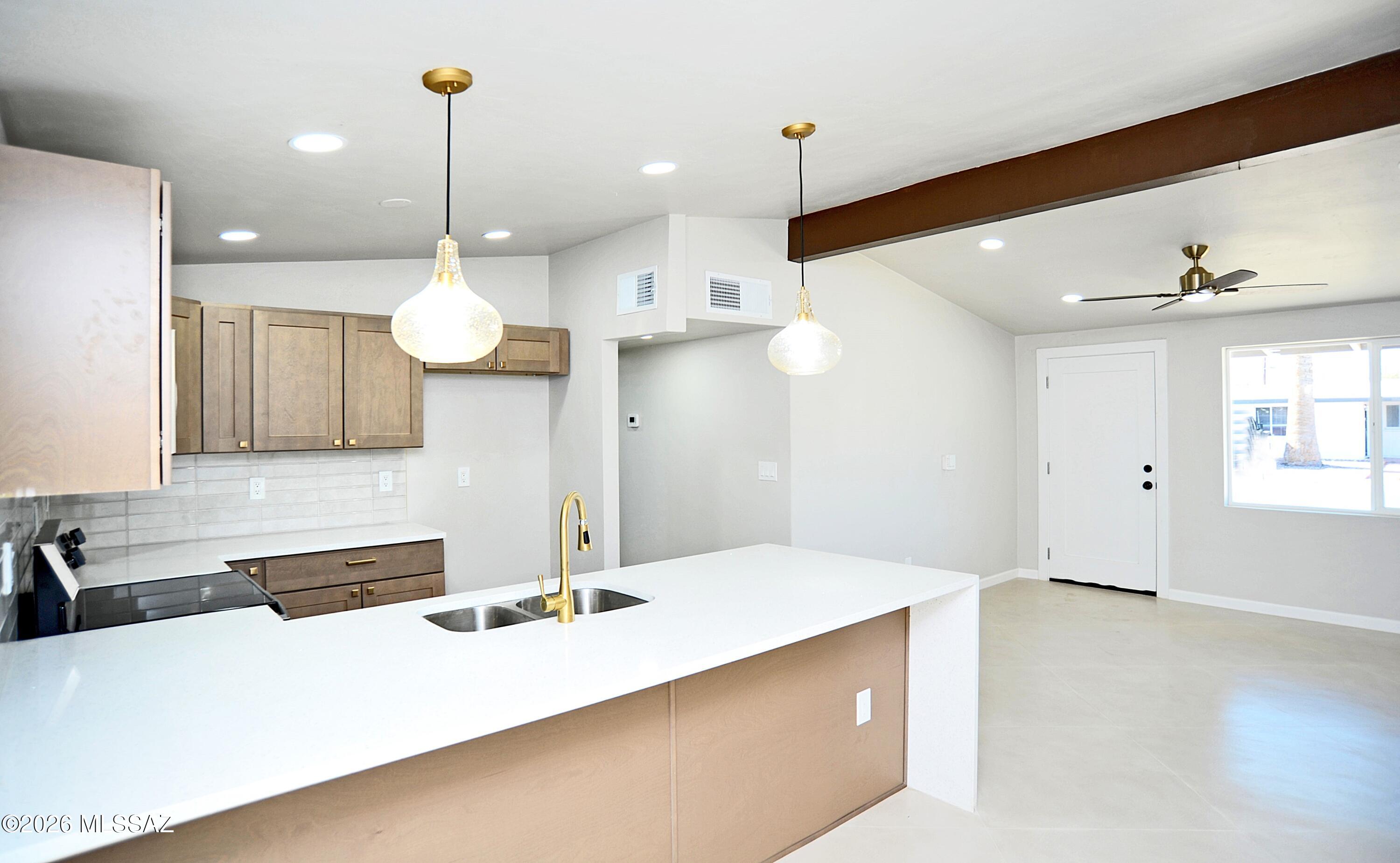 RANGE PRICED, SELLER WILL ENTERTAIN OFFERS FROM $275,000 TO $285,000! Beautifully remodeled home near Flowing Wells High School. Great location just minutes from I-10. New kitchen with quartz counter tops, custom concrete floors, and upgraded finishes throughout. Roof just coated, new windows, and new HVAC. This home is in near perfect move in condition. A huge bonus this home has a huge workshop and large lot. Don't let the square footage fool you, this one lays out large with a wonderful open floor plane. YOUR WILL LOVE THIS HOME! Owner/Agent