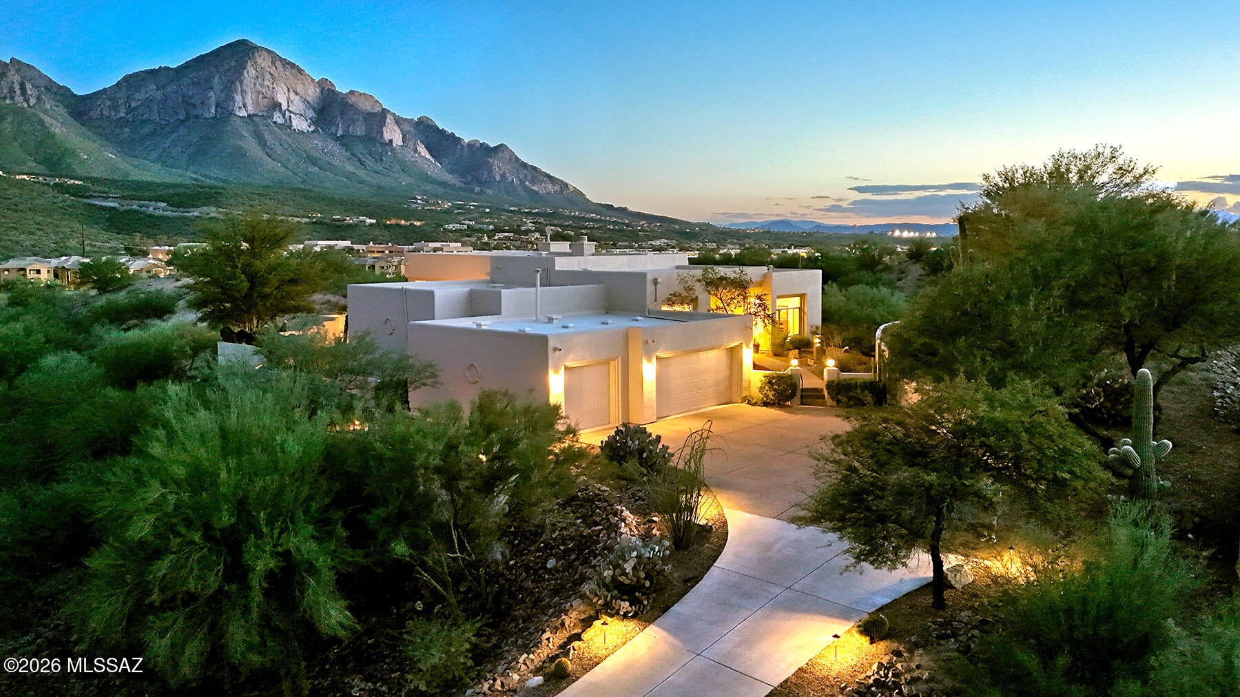 ELEGANT HILLTOP ESTATE WITH PANORAMIC PUSCH MOUNTAIN VIEWS! Perched high above the desert in a prestigious gated community and the end of a cul-de-sac, this exceptional custom estate captures sweeping, unobstructed Pusch Mountain views from its private 2.67-acre setting. Offering 4 bedrooms, 3 baths and approximately 3,334+ square feet, the residence combines refined Southwestern architecture, luxurious amenities and exceptional indoor/outdoor living with an extraordinary sense of privacy.  A Tucson Magazine award-winning kitchen serves as the heart of the home, beautifully redesigned with custom Alder cabinetry, Dekton countertops and premium stainless-steel appliances. The craftsmanship continues throughout with knotty Alder doors, rounded soffits, etched transom windows, architectural niches and skylights that fill the home with character and natural light.  The gracious primary suite is a private retreat featuring soaring ceilings, a dramatic Kiva fireplace and a spa-inspired bath with dual vanities. Thoughtfully designed living spaces flow effortlessly toward the outdoors, creating an ideal environment for both sophisticated entertaining and relaxed desert living.  Beyond the walls, the setting becomes truly spectacular. A PebbleTec resort-style pool and spa with waterfall are surrounded by generous patios, multiple seating areas and beautifully designed outdoor spaces positioned to take full advantage of the mountain panorama. Gather beneath the covered patio, relax on the turf area, or enjoy cool desert evenings beside the outdoor Kiva fireplace and built-in BBQ.  The approximately 953-square-foot three-car garage provides generous space for vehicles, storage and hobbies, while numerous recent improvements add to the home's appeal, including new carpeting in the den and secondary bedroom, fresh paint in the secondary bedroom, a new back-patio ceiling fan, new driveway lighting, new washer and dryer, and a new alarm system.  With its elevated hilltop location, spectacular mountain views, architectural character, award-winning kitchen and extraordinary resort-style outdoor living, this is a rare opportunity to experience privacy, elegance and the beauty of the Sonoran Desert in one remarkable