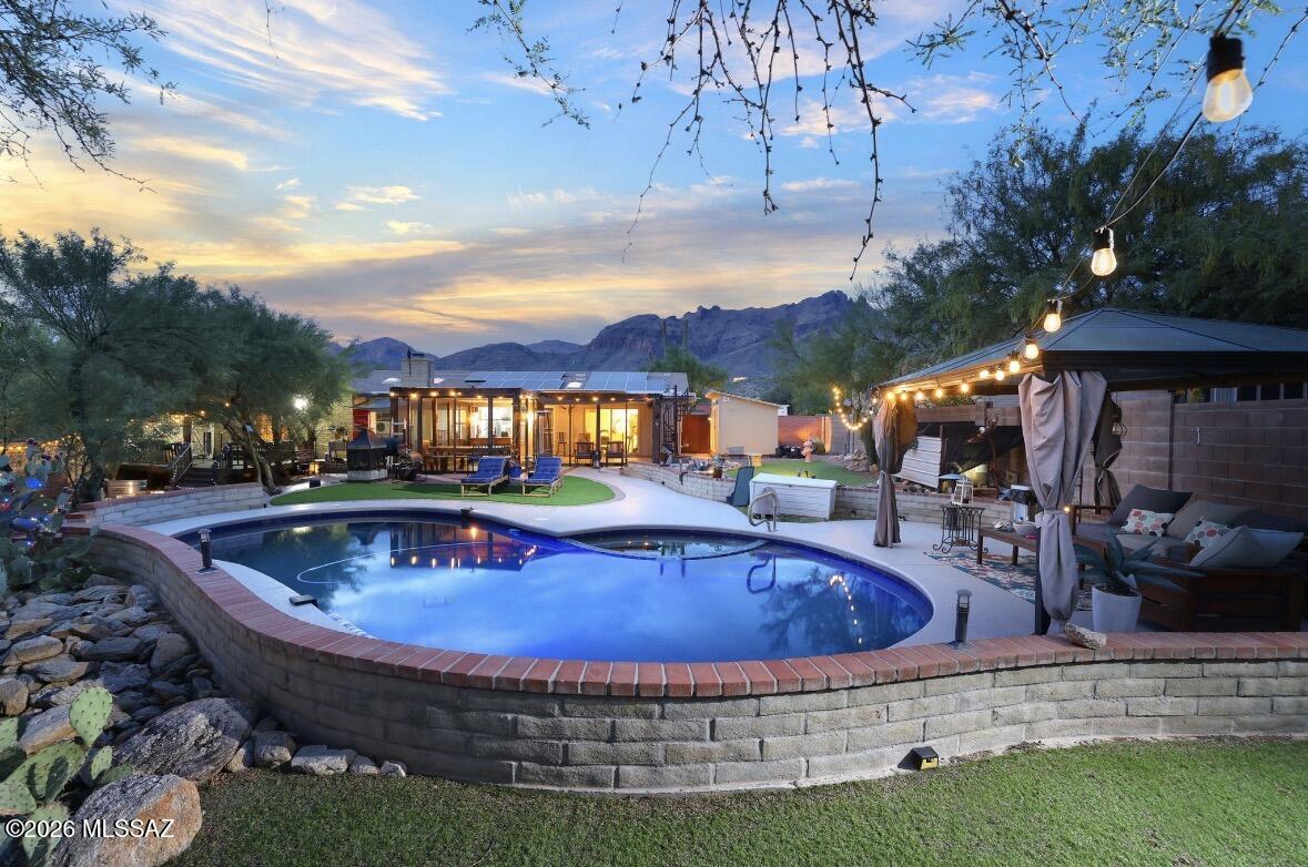 Welcome home! Ideally located just minutes from Tucson's premier amenities, including La Encantada, Fleming's, La Paloma, top-rated schools. Assumable 2.25% assumable v.a at 260k  
This inviting home features a welcoming floor plan with a front living room highlighted by a large picture window that showcases the beautiful mountain views. Over 100k in upgrades!!Recent updates include fresh interior paint, stunning new tile flooring, upgraded LED lighting, an updated kitchen with gorgeous granite countertops, matching granite in the bathrooms, a new tankless water heater, paid off solar, granite countertops, artificial grass! 
Currently configured as a three-bedroom home, there is also a spacious bonus room that could easily serve as a fourth bedroom, home office, or private study Once you've fallen in love with the interior, the outdoor living spaces are sure to impress. Step through the enclosed Arizona room, located just off the oversized private laundry room, and into your fully covered, screened-in patio, which is fully permitted and perfect for outdoor projects, family dinners, or arts and crafts while being protected from the desert wildlife.
The resort-style backyard is an entertainer's dream, featuring a freshly re-pebbled pool and spa with a newly painted pool deck. A covered ramada provides the perfect setting for barbecues, gatherings with family and friends, or simply relaxing and escaping the summer heat.
The primary suite offers its own private deck, where you can step outside each morning or evening to enjoy beautiful city views. A steel staircase leads to an incredible rooftop deck with panoramic mountain and city views, creating a one-of-a-kind space to watch Arizona's spectacular sunsets.
This home has been lovingly cared for and offers numerous additional upgrades, including a well-maintained roof, paid-off solar for significant energy savings, a recently replaced insulated garage door, an upgraded water softener, and a central vacuum system throughout.
Come experience this exceptional home for yourself, schedule your private showing today