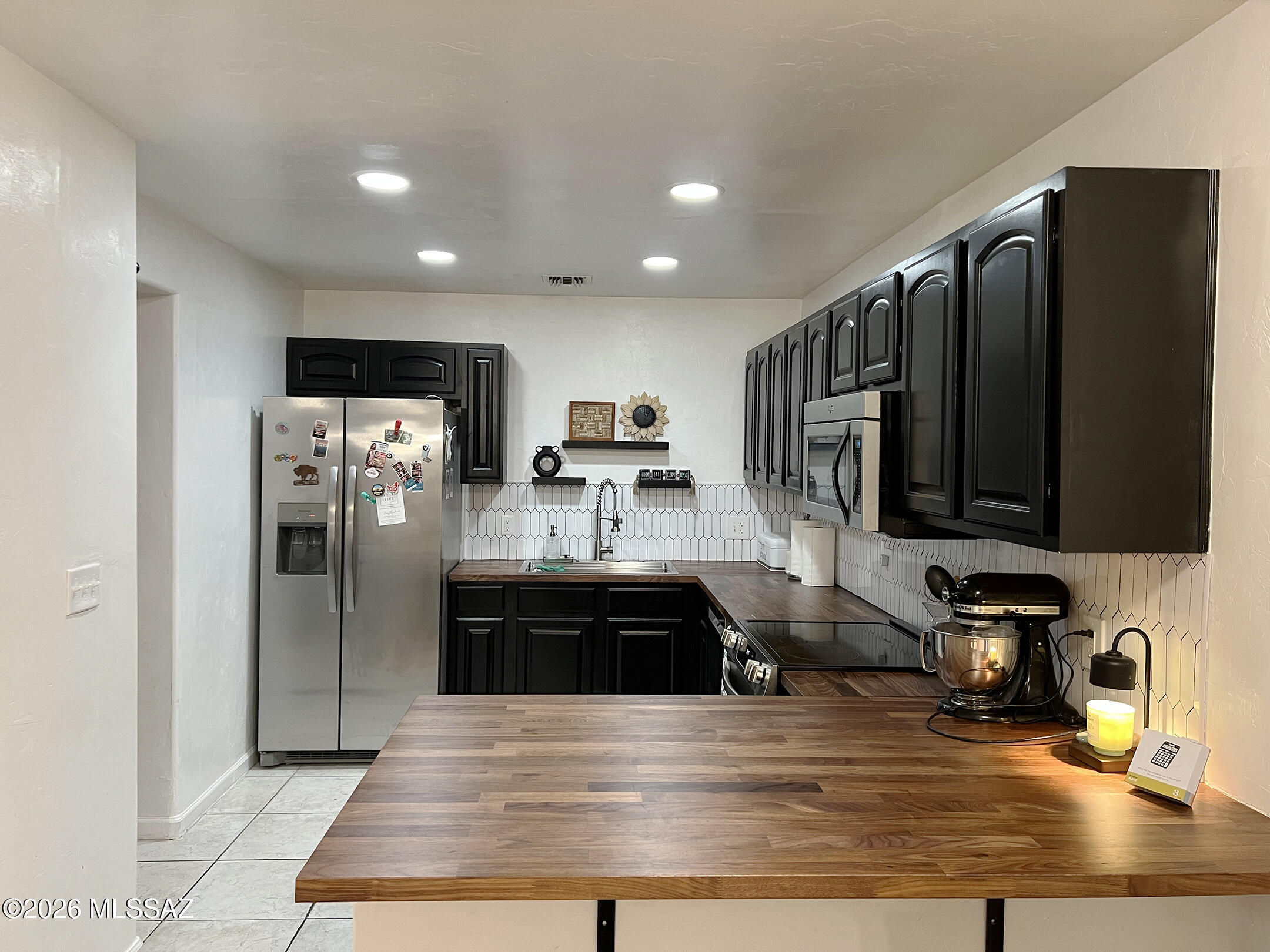 Beautifully Updated Ground Floor, Two-Bedroom, One Bathroom Condo with Mountain Views! Gorgeous Kitchen Remodeled in 2026 with Walnut Butcher Block Countertops and an Improved Breakfast Bar.  Refrigerator, Range, and Dishwasher (2025).  Bathroom Completely Remodeled in 2025 including Vanity, Tub/Shower and Flooring.  Water Heater (2024).  Spacious Master Bedroom with Sliding Barn Door, Ample Closet Space, and Access to the Enclosed Courtyard Landscaped with Artificial Turf and Pavers, perfect for relaxing.  Wood Laminate Flooring in Both Bedrooms and Hallway.  Open-Concept Great Room with Wood-Burning Fireplace with Mantel.  Reflections in the Catalinas Community offers a Community Center, Pool, Jacuzzi, BBQ and Fitness Facility.  HOA covers Trash, Water/Sewer, Roof, Streets, and Grounds.