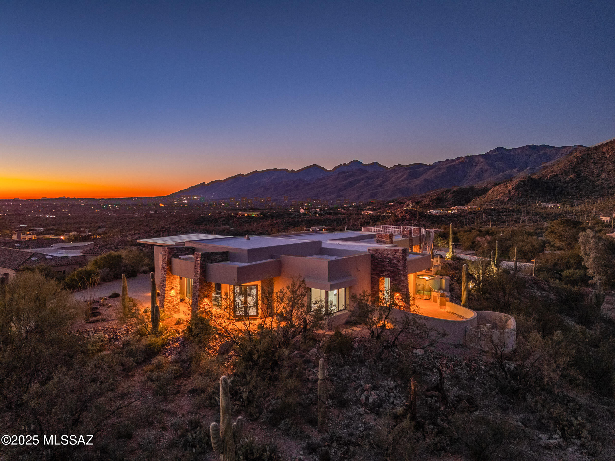 Perched hilltop and resting on one of the best homesites in Redington Ranch, find luxurious Tucson living at its finest! This thoughtfully designed & custom-built sanctuary waits for you to come home. Grandiose & poised, with truly magical 360-degree views; when the sunlight hits just right at every hour of the day, and where tranquility can be found at every turn. The soaring high ceilings and expansive windows offer a timeless elegance while showing off the dancing mountain ranges. Clean lines, neutral colors, and a contemporary aesthetic, serves as the perfect foundation to feature your own style, design, or art collection. The great room, with see-through fireplace, flows into the formal dining and gourmet kitchen. Custom cabinetry, premium appliances, a huge island and wet bar... make entertaining a breeze. This impressive property is stacked with as many amenities as it is beautiful! Includes the convenience and luxury of owned solar and community equestrian facilities!