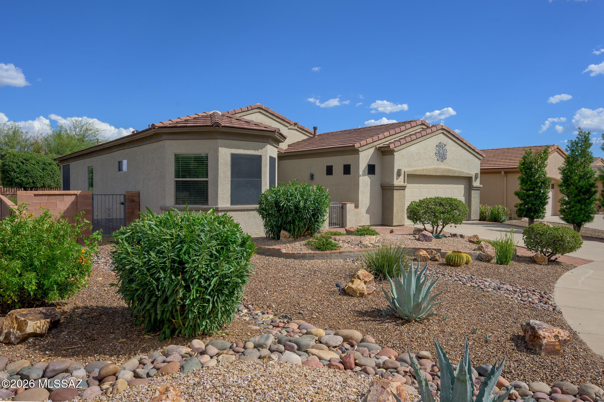 Discover effortless retirement living in this beautifully maintained home tucked away at the end of a peaceful cul-de-sac within a premier 55+ community in the Sonoran Desert. Surrounded by natural desert common areas, this home offers unrivaled privacy and stunning desert views right from your doorstep. The inviting curb appeal features elegant gabled tile roof lines and low-maintenance desert landscaping, providing a warm welcome to guests.  Step inside to graceful soft arches that define the living spaces, complemented by gorgeous tile flooring with intricate edging and matching tile baseboards throughout. The heart of the home is a chef's kitchen boasting rich cabinetry, a stylish stone backsplash, gas range, and sleek stainless appliances. The kitchen seamlessly flows into a spacious family room, anchored by a cozy stone-faced gas fireplace, creating the perfect spot for relaxing or entertaining.  A versatile room just off the kitchen can serve as a formal dining area or a light-filled office. Both bedrooms are generously sized, with a desirable split layout that ensures guest privacy. The primary suite features a dual-sink vanity and an oversized tiled shower for a spa-like experience.  Enjoy the outdoors year-round on the covered patio with remote-controlled screens for added comfort and privacy. An extended paver patio offers even more space to savor Arizona's beautiful weather. The oversized two-car garage delights with abundant cabinetry, a built-in workstation, and a work sink for hobbies. You'll appreciate the added peace of mind of the HVAC system, replaced in September 2026.  Located in a 55+ community focused on active living, this home blends comfort, function, and style for the active retiree.