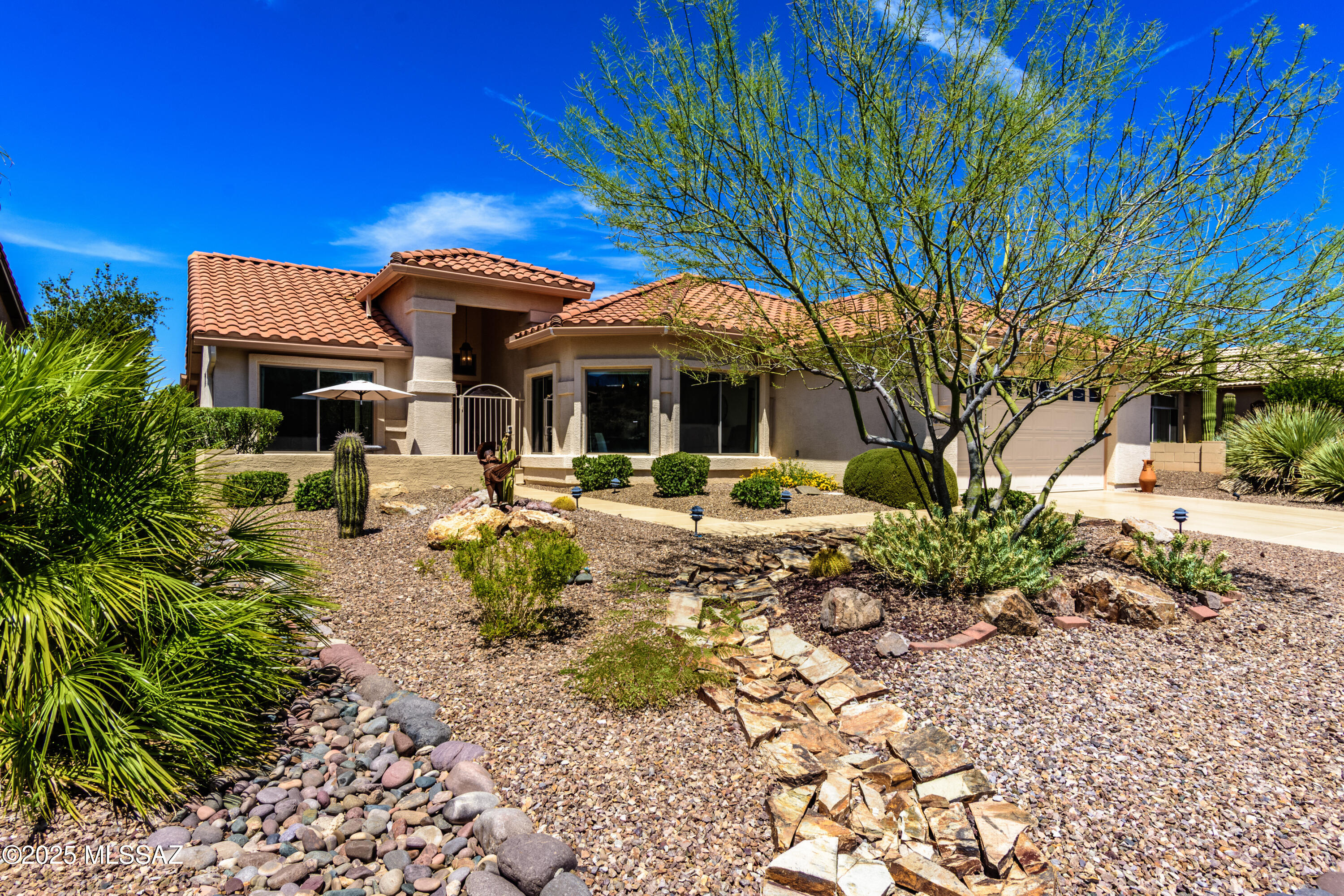 Rare premium lot:  Golf Course Vistas or Mountain views from every room. Add to this, the comfort you've been waiting for and the lifestyle to match.  Savor the ease & convenience of this unique SaddleBrooke home. This elegantly updated, extended Laredo model offers a spacious, comfortable layout w/split 3BD/2BA or Den --perfect for hobbies, guests, or a quiet reading room. An open living area w/fireplace inspires easy nights in & welcoming occasions. Love to cook or entertain? (read on!) The kitchen is a dream, w/quartz countertops, updated white cabinetry, SS appliances, a breakfast bar, & a dining area that showcases those stunning mountain views. Relax within your private backyard retreat, this premium lot situated on the 12th Golf Course green, where decorative turf & tranquil cascading waterfall create a peaceful space to unwind or host friends. New irrigation drip system and water feature pump. 

Peaceful spaces. Modern touches. Pure Tucson charm. Your gated courtyard is just moments from nearby Golf paths & the village center where there's a bank, market, gas, dentist, computer store & more. Your new home simplifies the active, connected lifestyle available within this dynamic community. Furniture avbl on separate BOS. Pool-sized backyard.